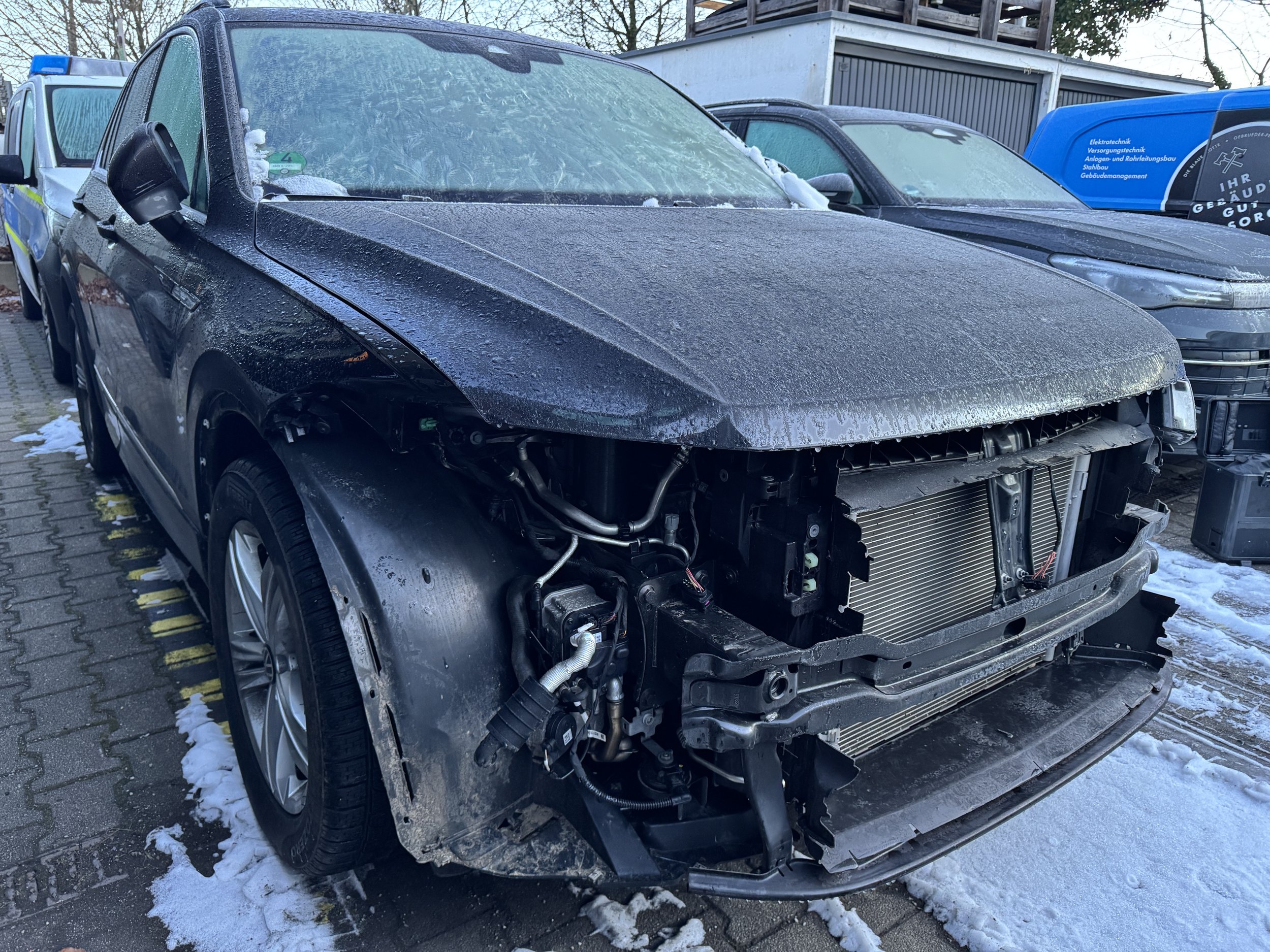 Schwerer Unfallschaden an der Fahrzeugfront eines BMW SUV mit freiliegendem Kühlsystem – Schadensgutachten Olympia Kfz-Gutachten München