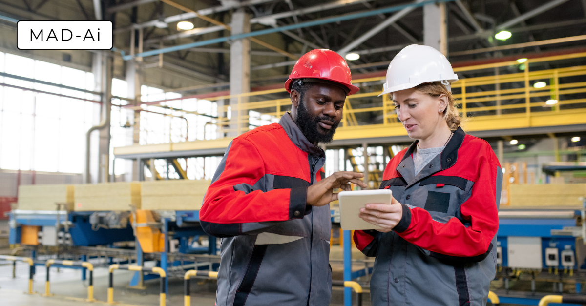 Industrial robotic arms working on a car assembly line in a factory.