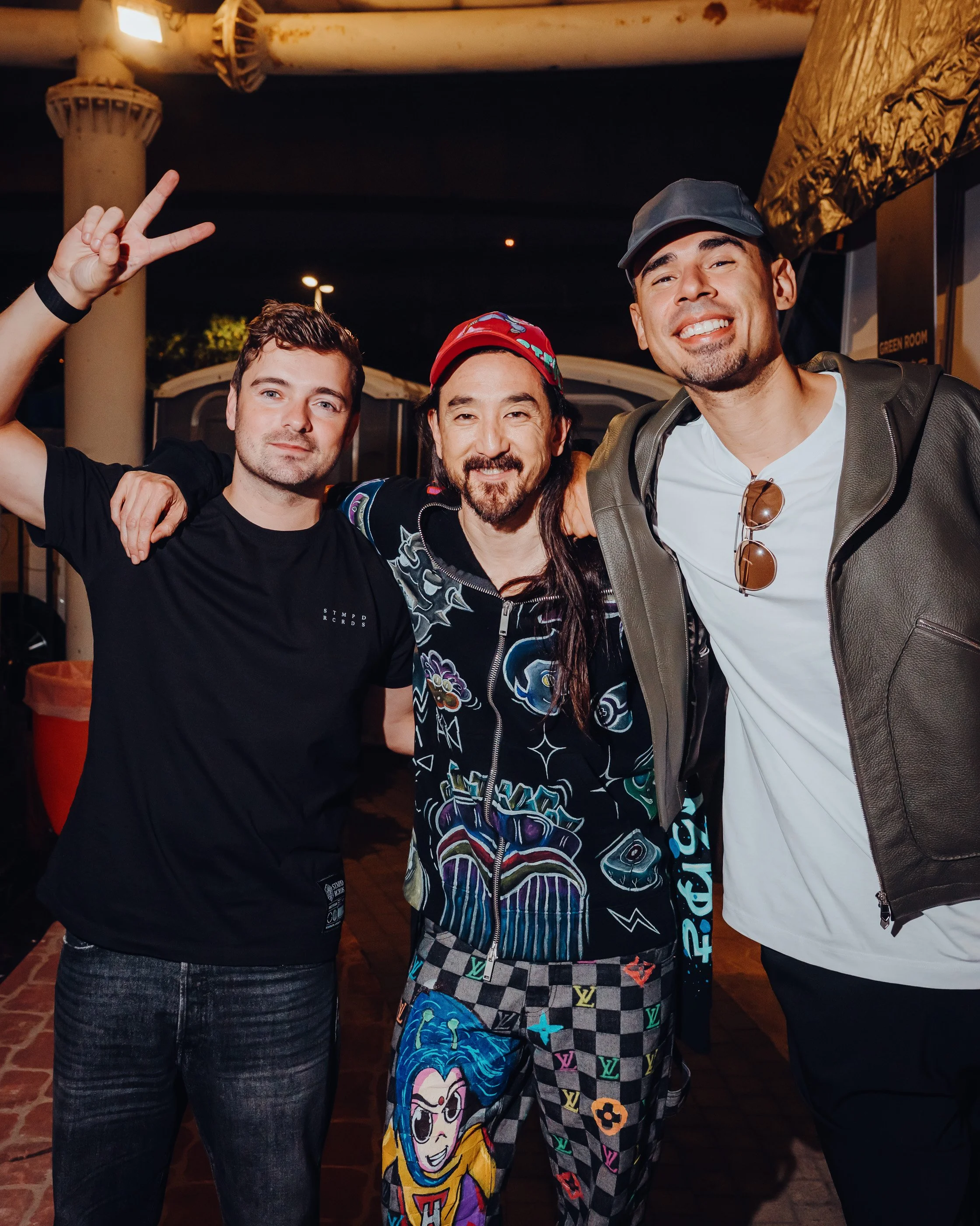 Steve Aoki (middle) surrounded by Martin Garrix (left) and Afro Jack (right) taken by James Bridle Photography 