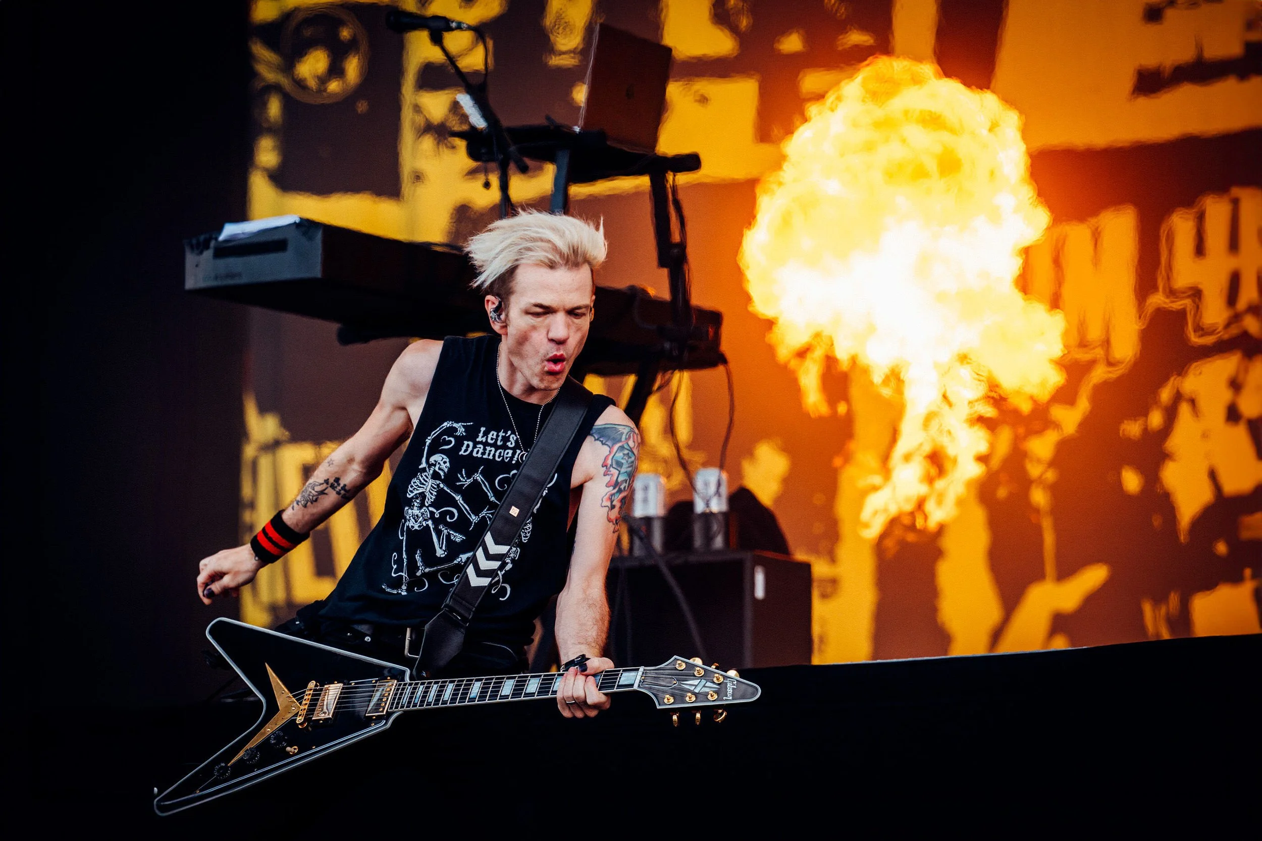 Deryck Whibley of Sum41 performs on stage with flames in the background at Download Festival 2024 MainStage captured by James Bridle Music photographer on behalf of Fanatic and Live Nation. 