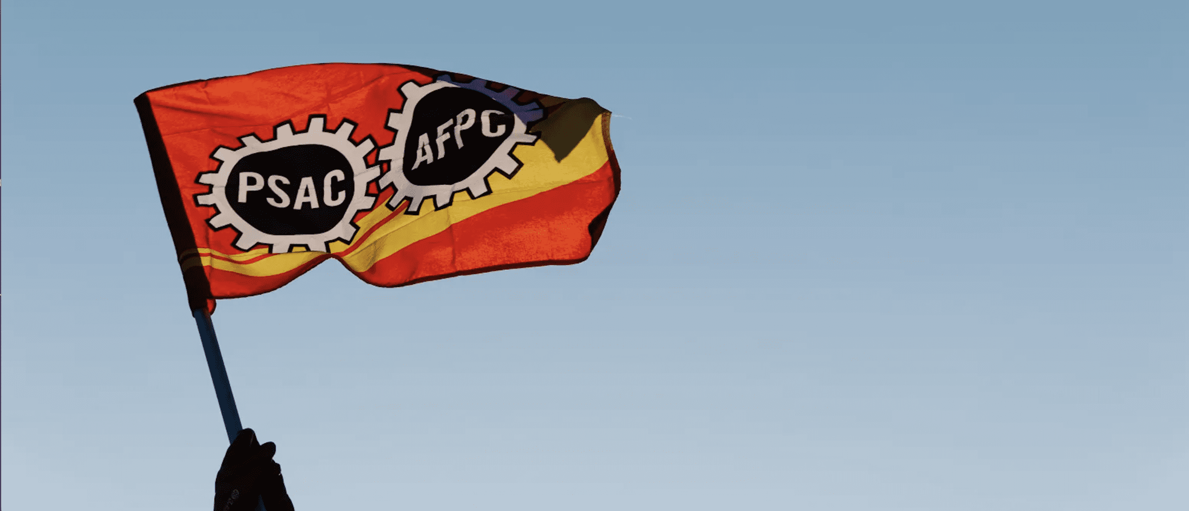 PSAC flag waving infant of a blue sky