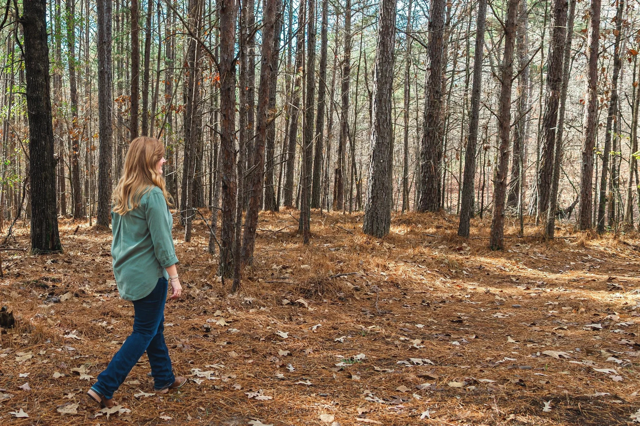 Deidre King, Certified LifePlan Guide, walking through a peaceful Alabama forest during a reflective moment.