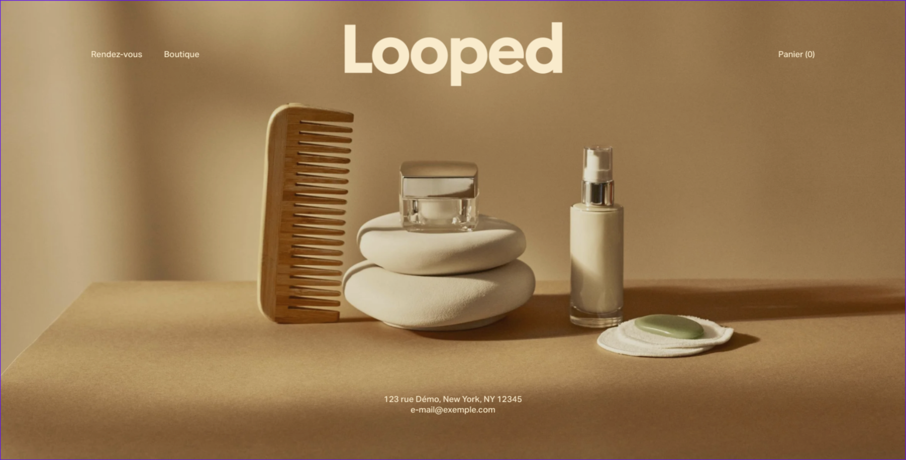 Page d'accueil d'une boutique de produits de soin, avec une brosse en bois, un petit pot, deux pierres plates et une bouteille avec pompe, ainsi qu'un savon posé sur un tissu blanc, au centre de l'image.