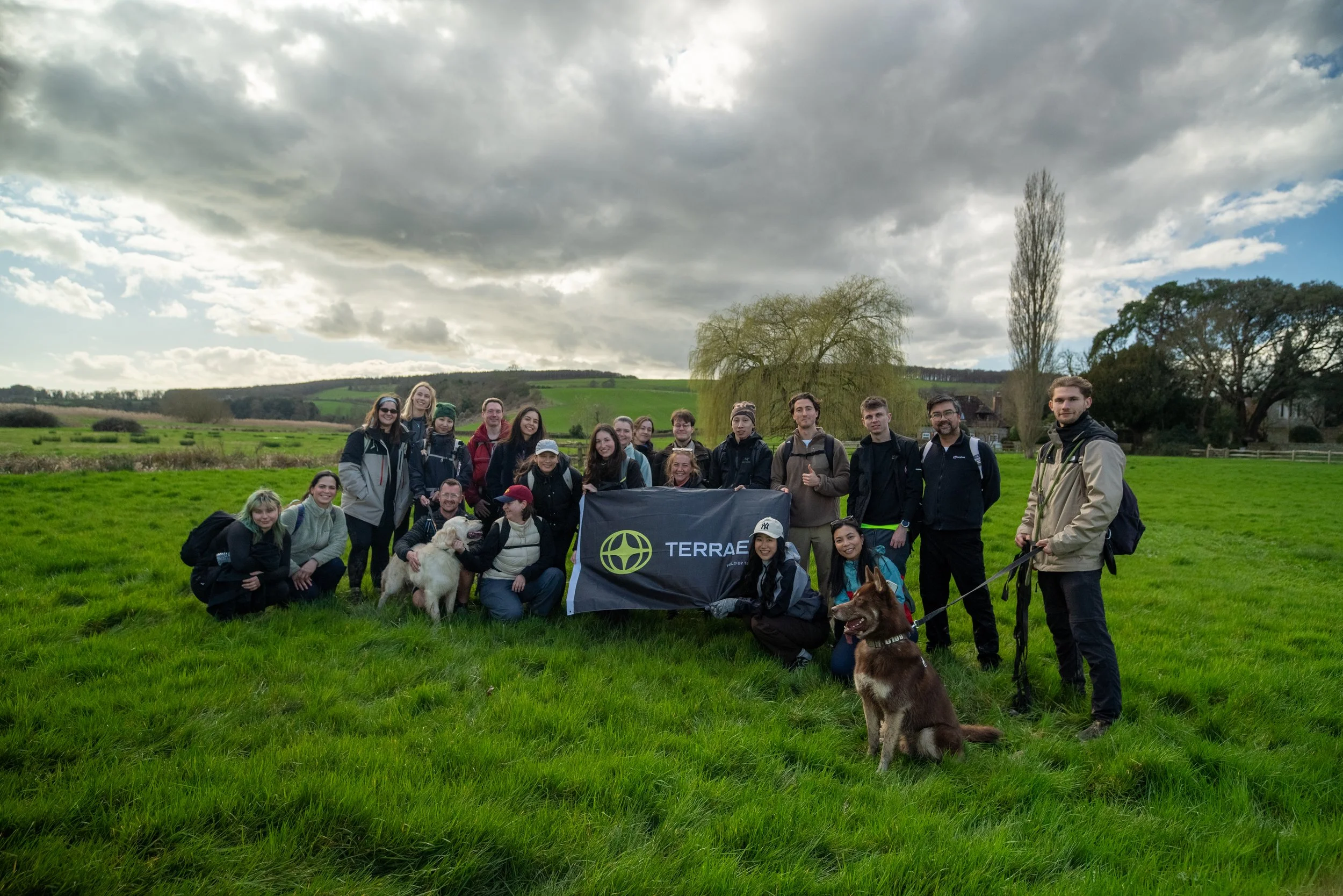 Landscape with a castle on a hill in the background, a body of water in the foreground, and lush green fields and trees.