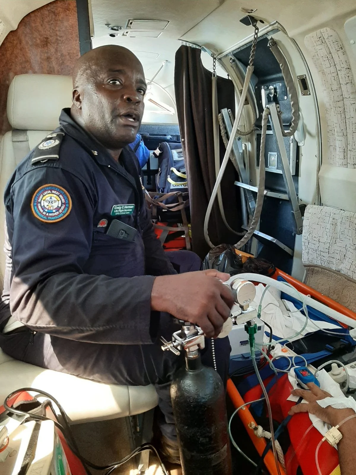 Emergency medical worker seated inside a helicopter, preparing medical equipment.
