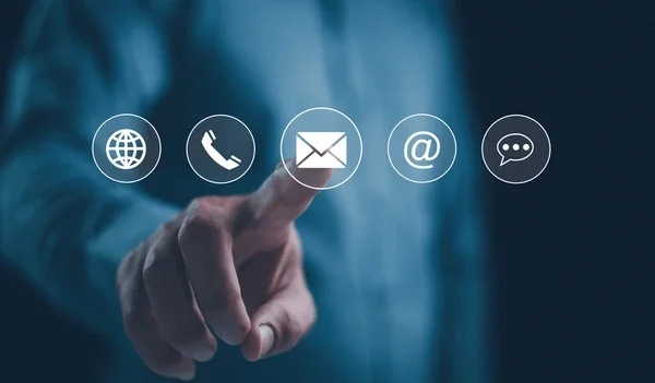 A person in a dark blue shirt pointing at a digital contact icons overlay including a globe, phone, email, at symbol, and speech bubble.