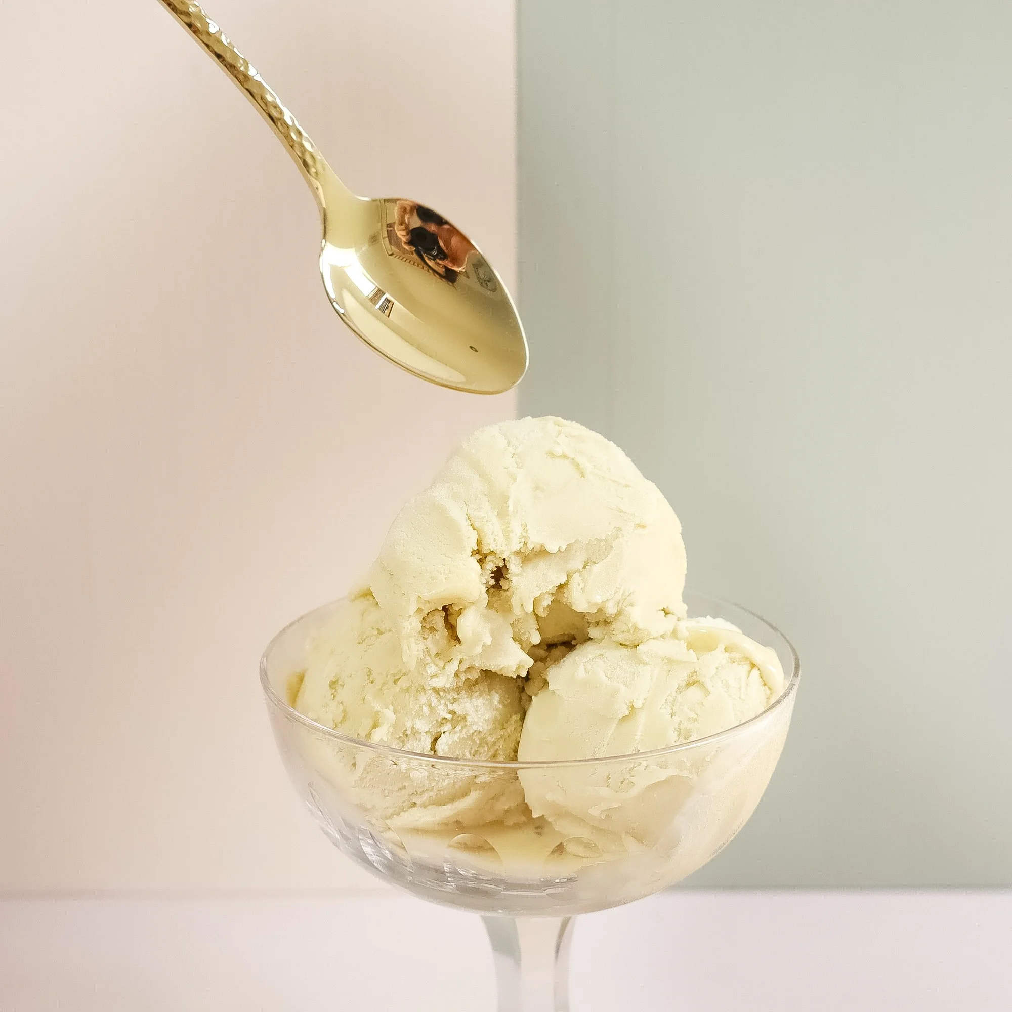 Arthur Price golden teaspoon delving into a large scoop of pistachio gelato.