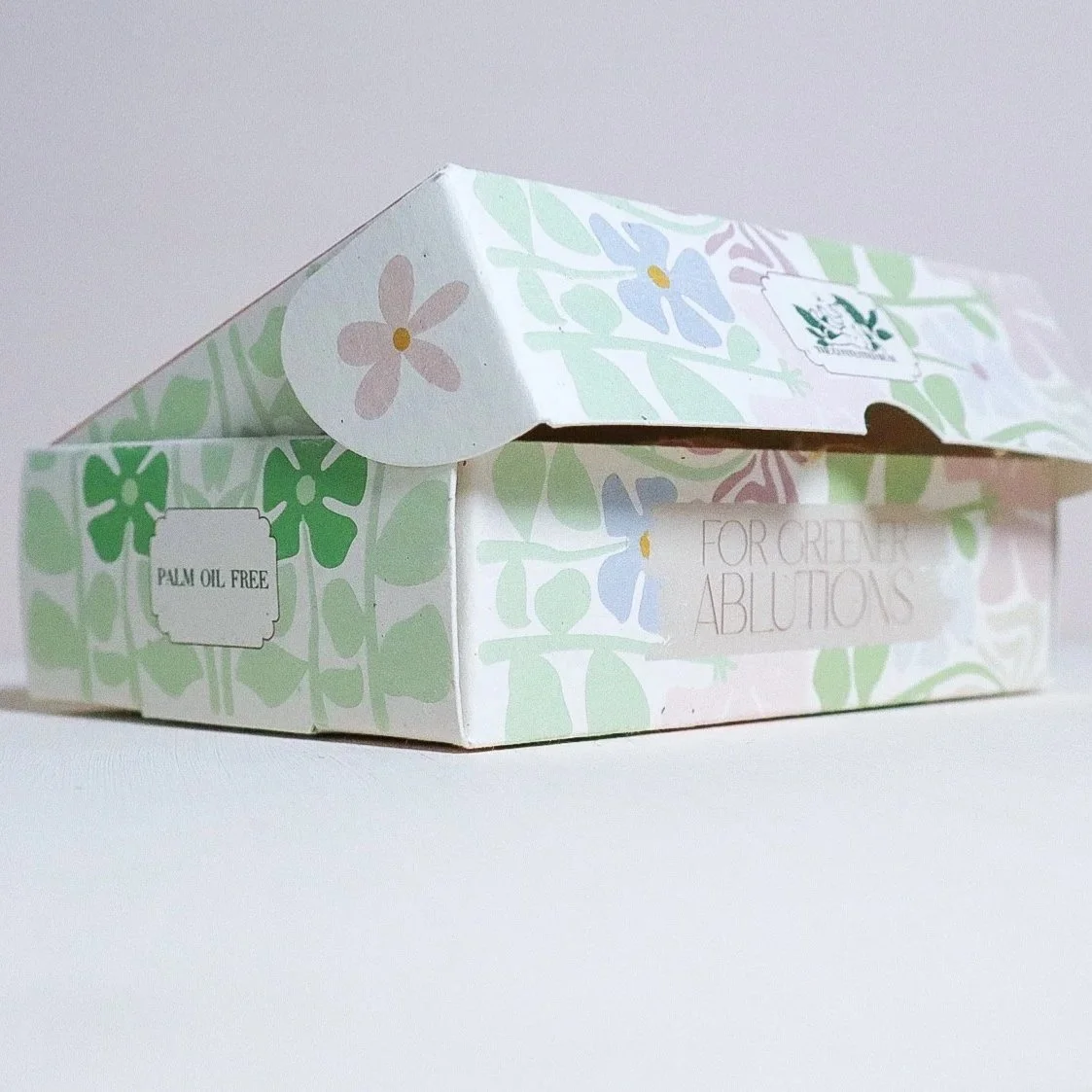 Pastel coloured, flower printed luxury recycled card soap box from a side view, slightly opened.