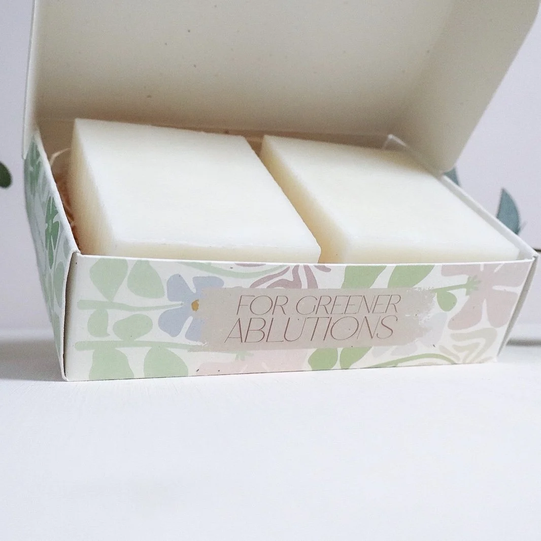 A side view of an open soap box tilted to show two beautiful hand made soaps.