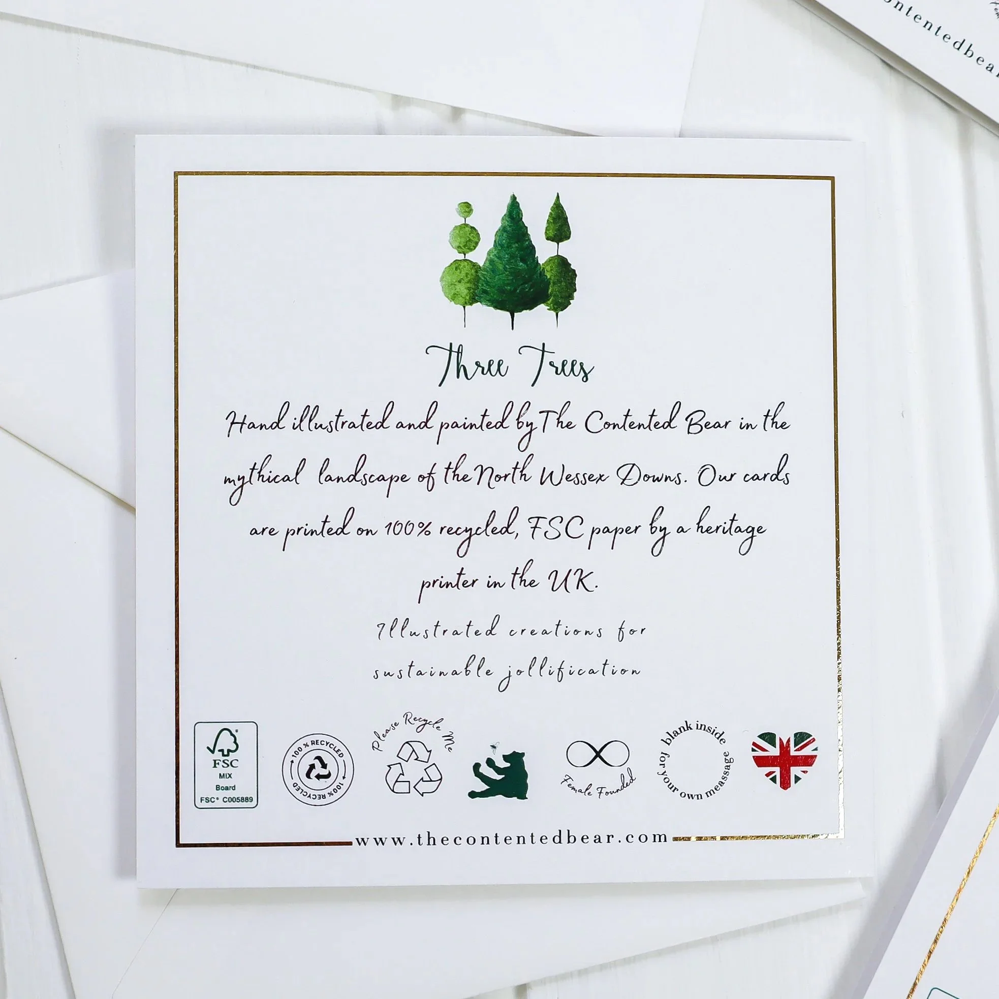 Aerial view of the back of the three trees Christmas card with gold foil.