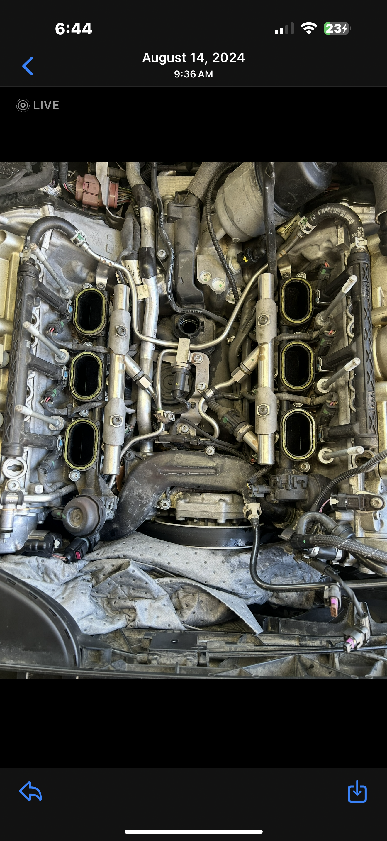 View of an engine with the intake manifold removed, exposing intake ports and various mechanical components.