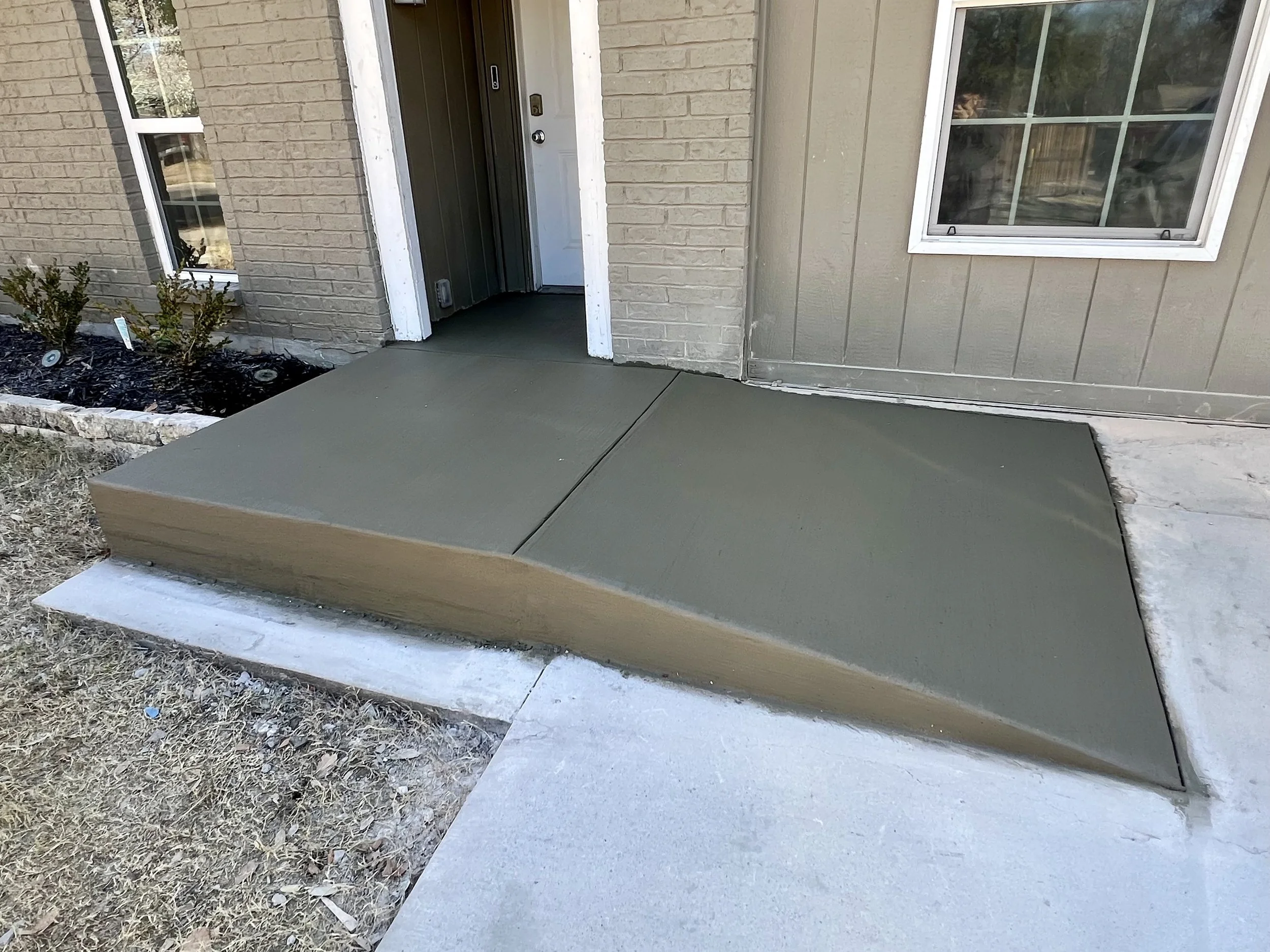 Freshly poured concrete walk leading to house entrance.