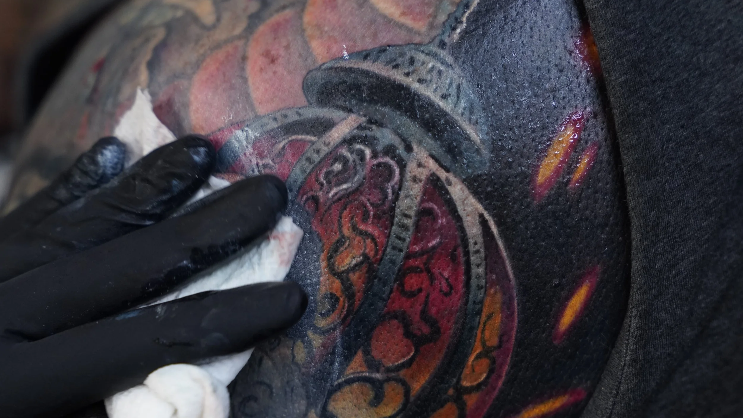 Close-up of a colorful custom cover-up tattoo at Black Nova Tattoo Collective in Miami, showcasing vibrant color saturation and detailed realism.