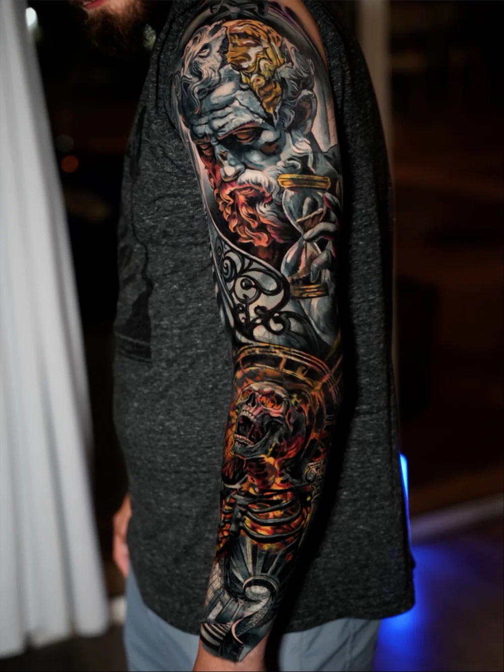 Full sleeve cover-up with a classical bearded figure, hourglass and skull in red and gold tones