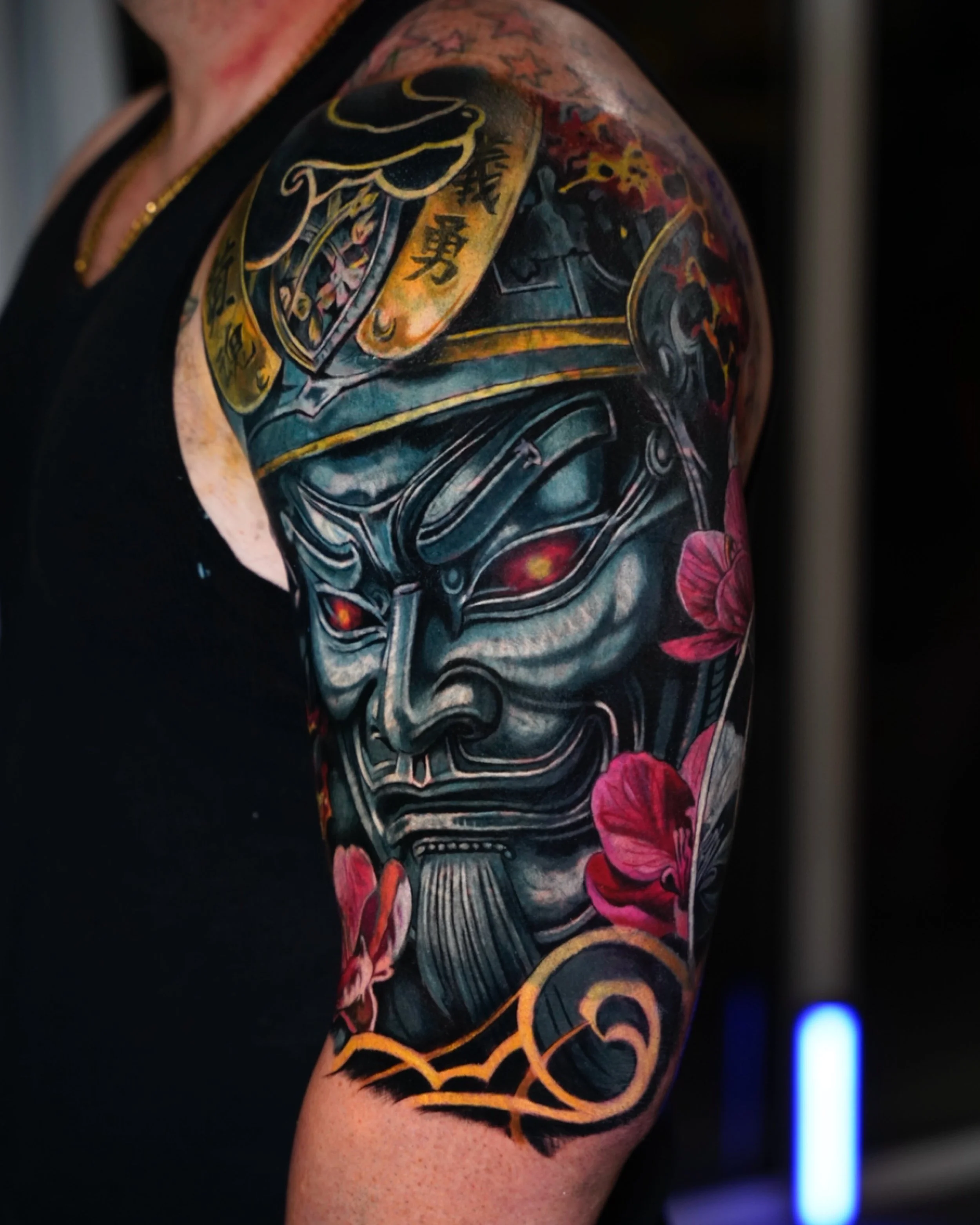 Large scale color realism cover up tattoo featuring a Japanese mask, successfully covering an old dark tattoo.