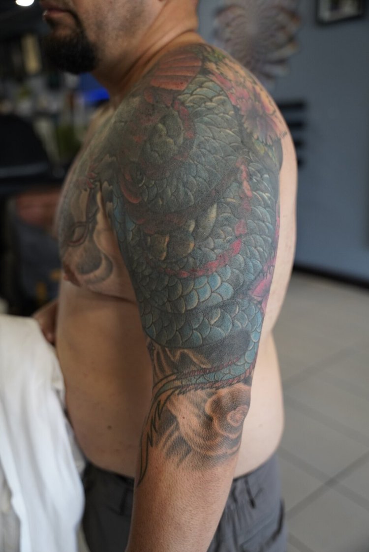 Faded upper-arm tattoo before the Buddha shoulder cover-up.