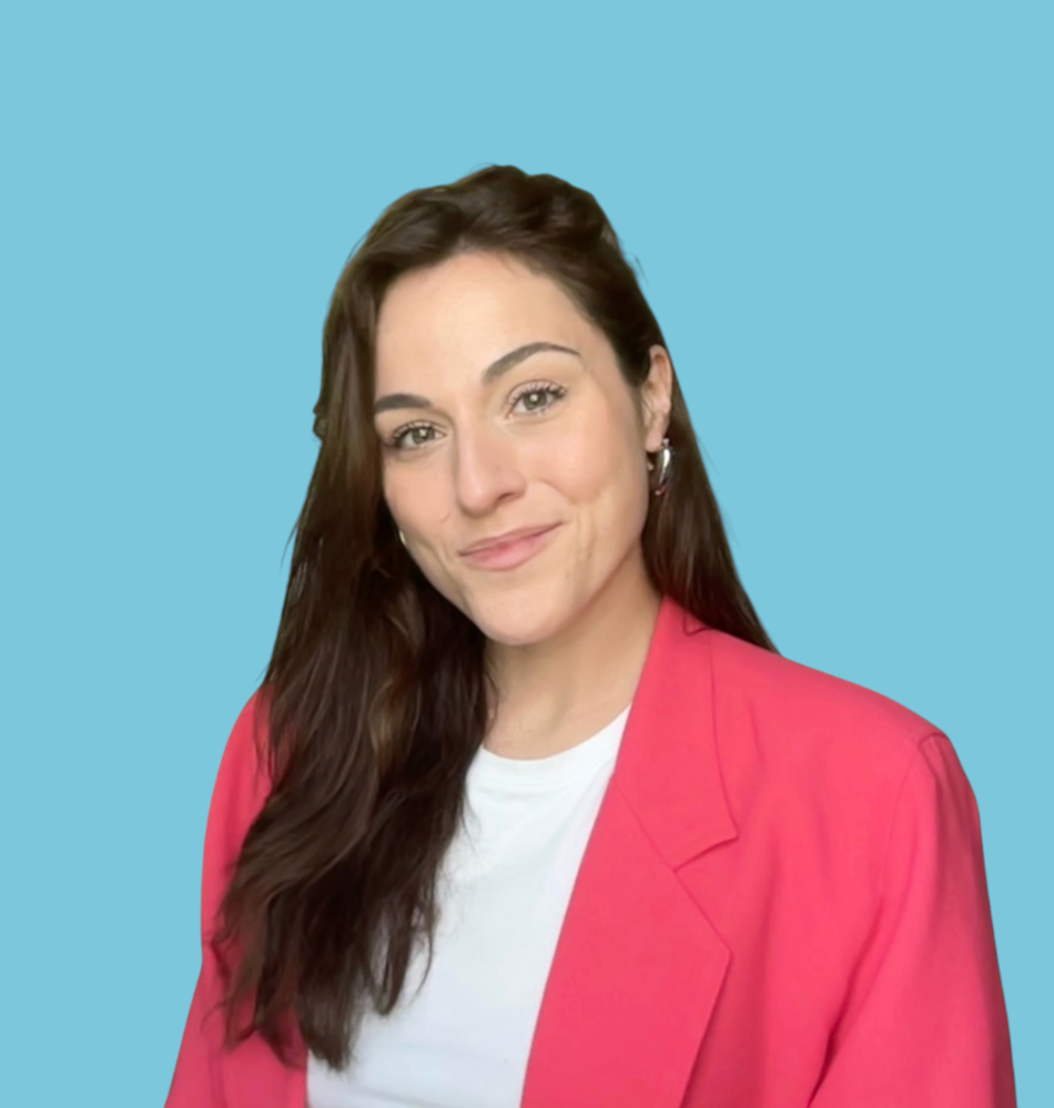 Une femme souriante portant une veste rose et un t-shirt blanc, sur un fond bleu.