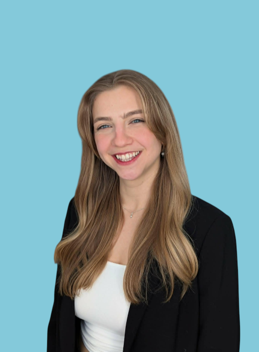 Jeune femme souriante avec des cheveux longs et blond, portant une veste noire et un chemisier blanc, contre un fond bleu.