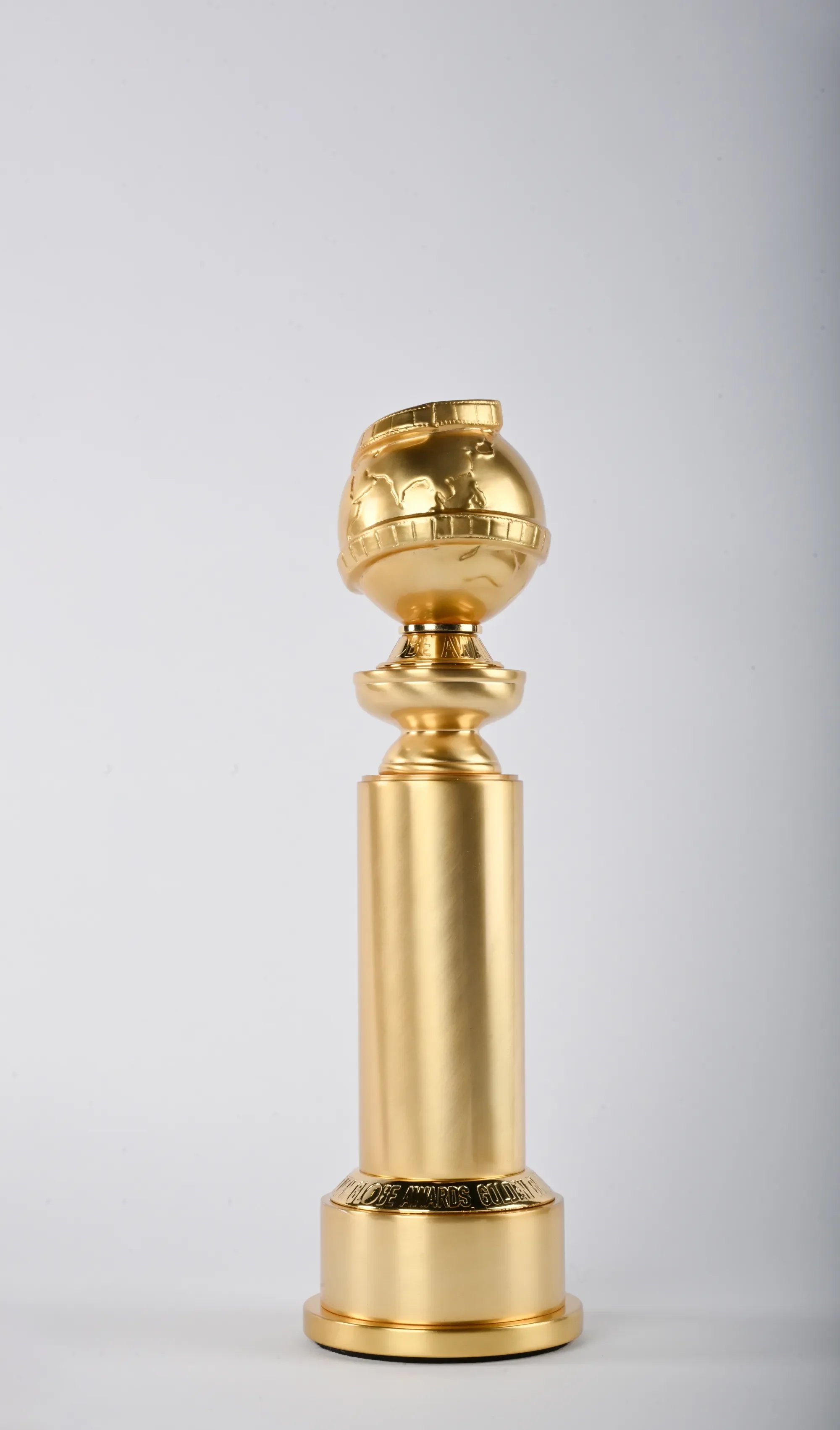 A gold globe trophy on a gold pedestal, with the words "PRIZE AWARDS GOLDEN" engraved on the base.