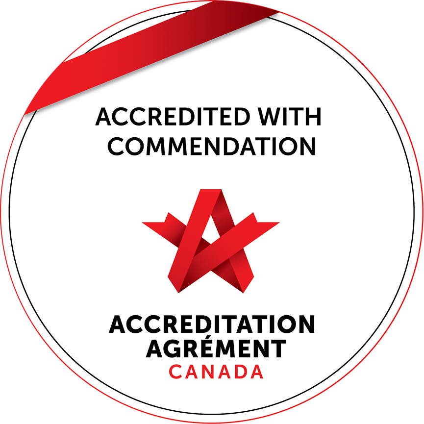 A circular badge with a red and white color scheme, featuring the text "Accredited with Commendation" and "Accreditation" in black, and "Canada" in red. It includes a red ribbon emblem in the center.