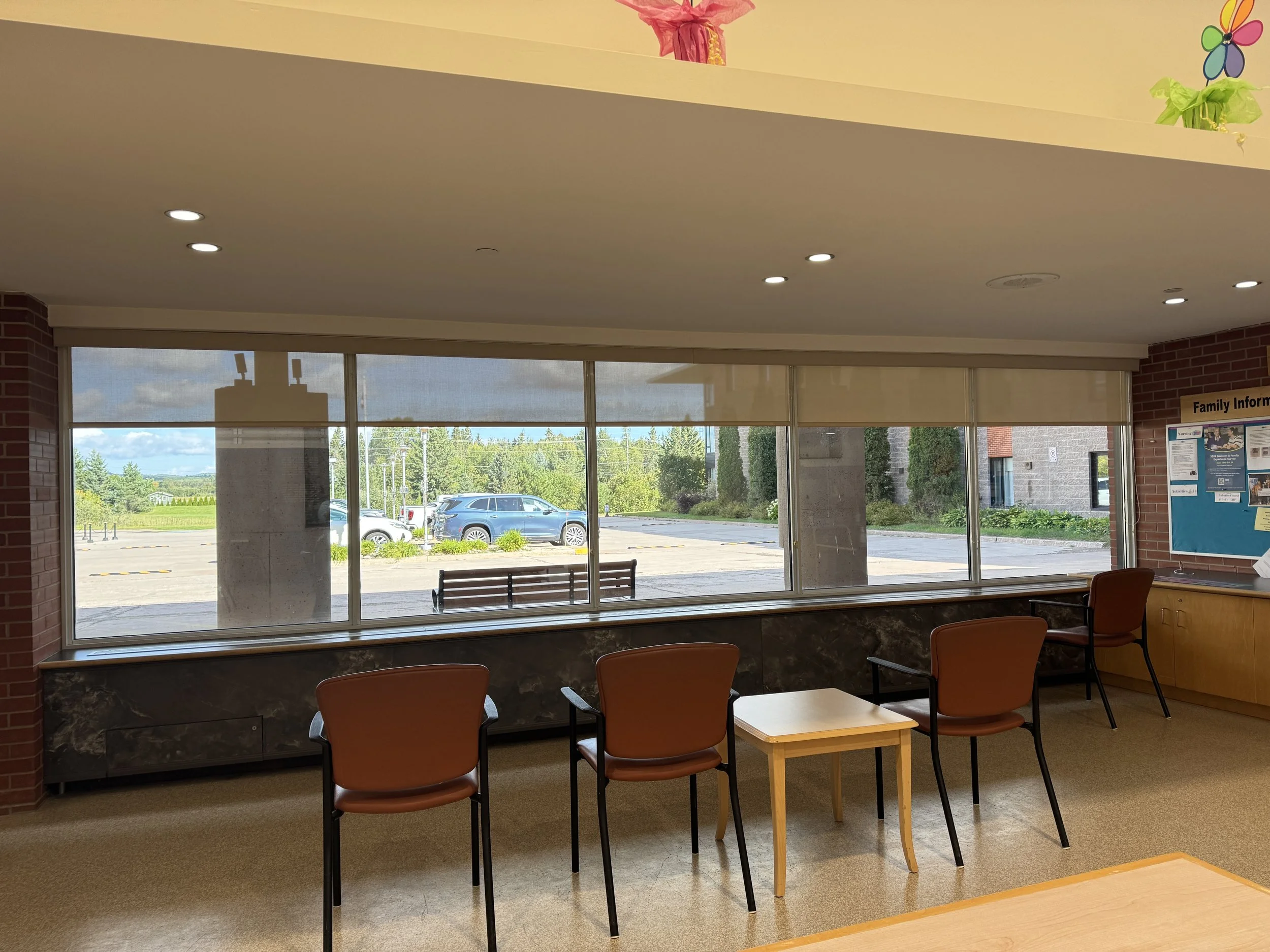 This resident lounge is a comfortable space where residents can sit, relax, and enjoy the view outside. It is also a welcoming area for residents to wait for family members, say goodbye when they leave, or sit and watch people coming and going. A nic