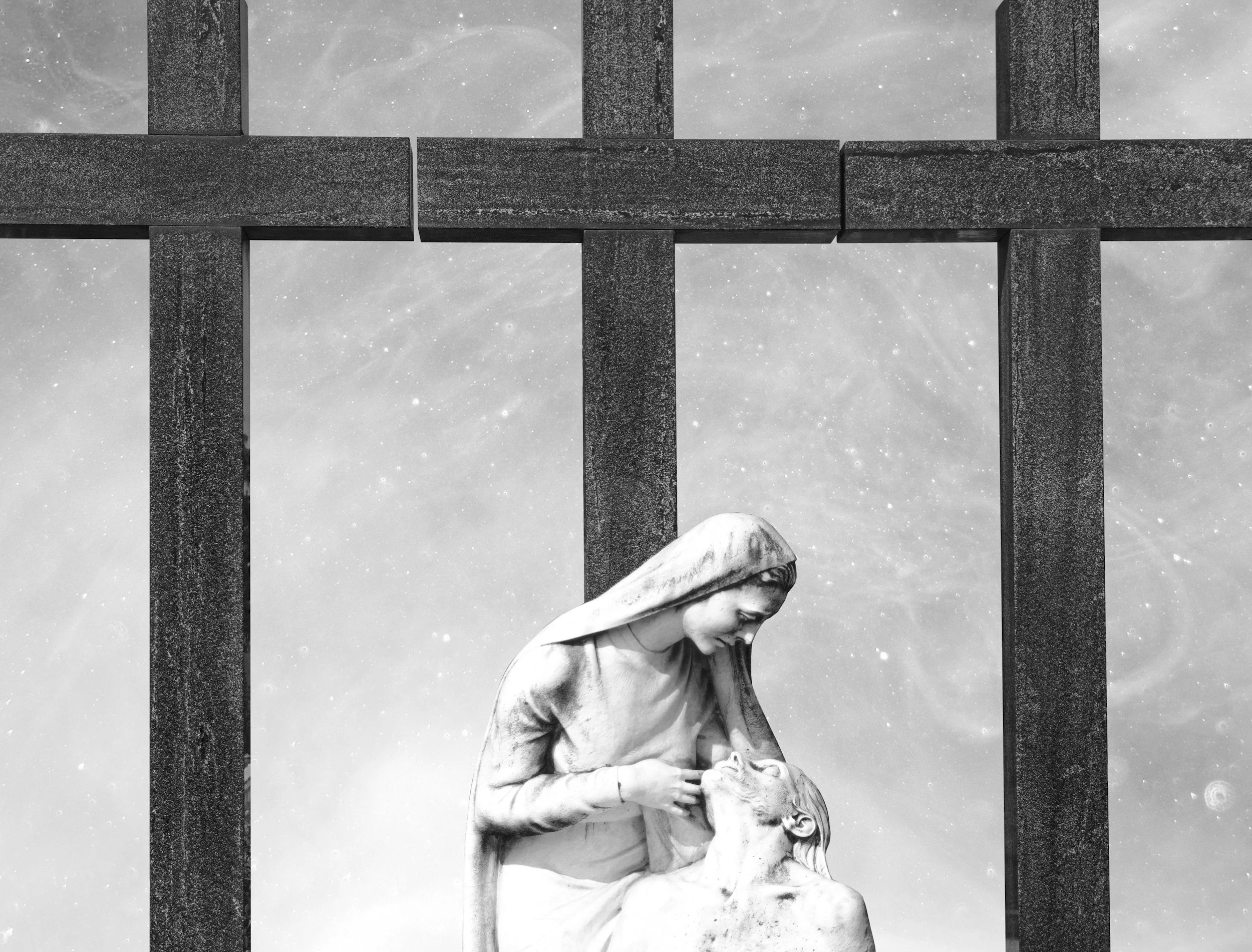 A black and white sculpture of a woman looking down at a man lying in her lap, with a cross-shaped structure in the background and a starry sky.