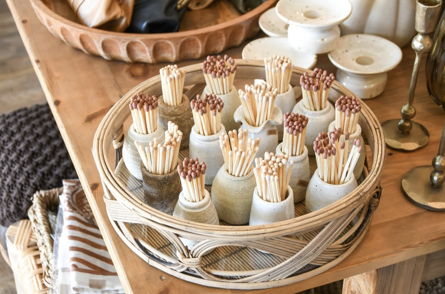Ceramic vases filled with wooden matches on a wooden table.
