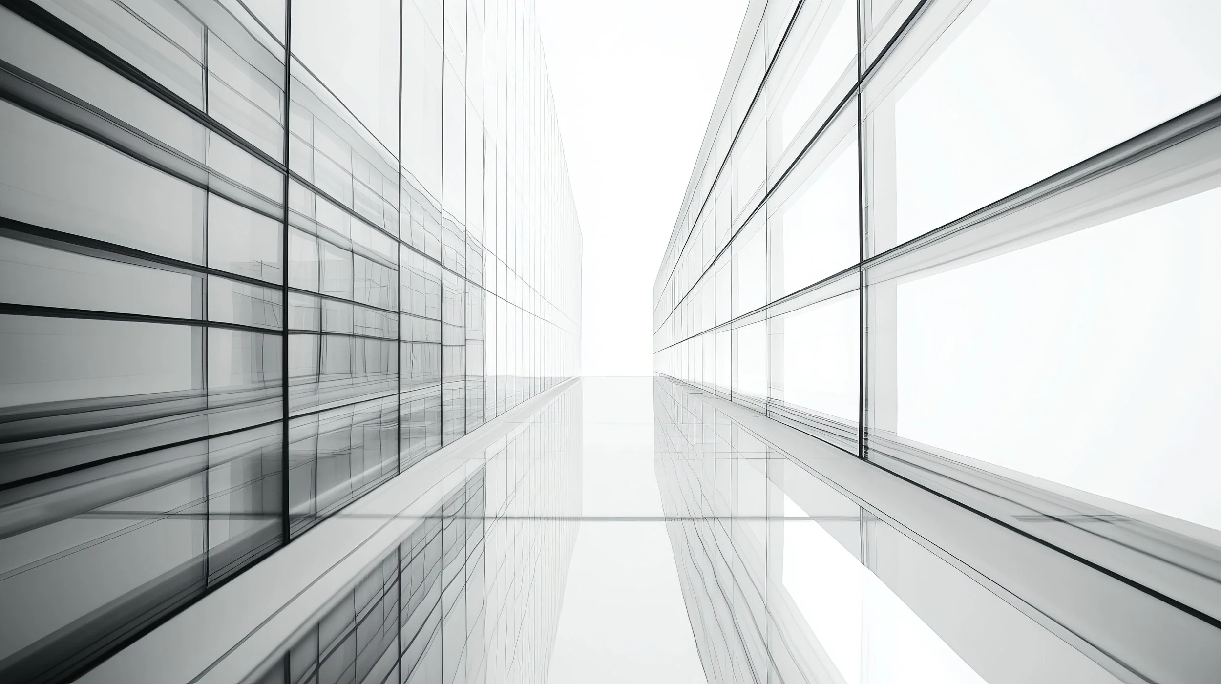 Looking up between two modern glass skyscrapers with reflective windows, converging towards the bright sky symbolizing lofty aspirations that can be obtained by foundational groundwork and elegant design.
