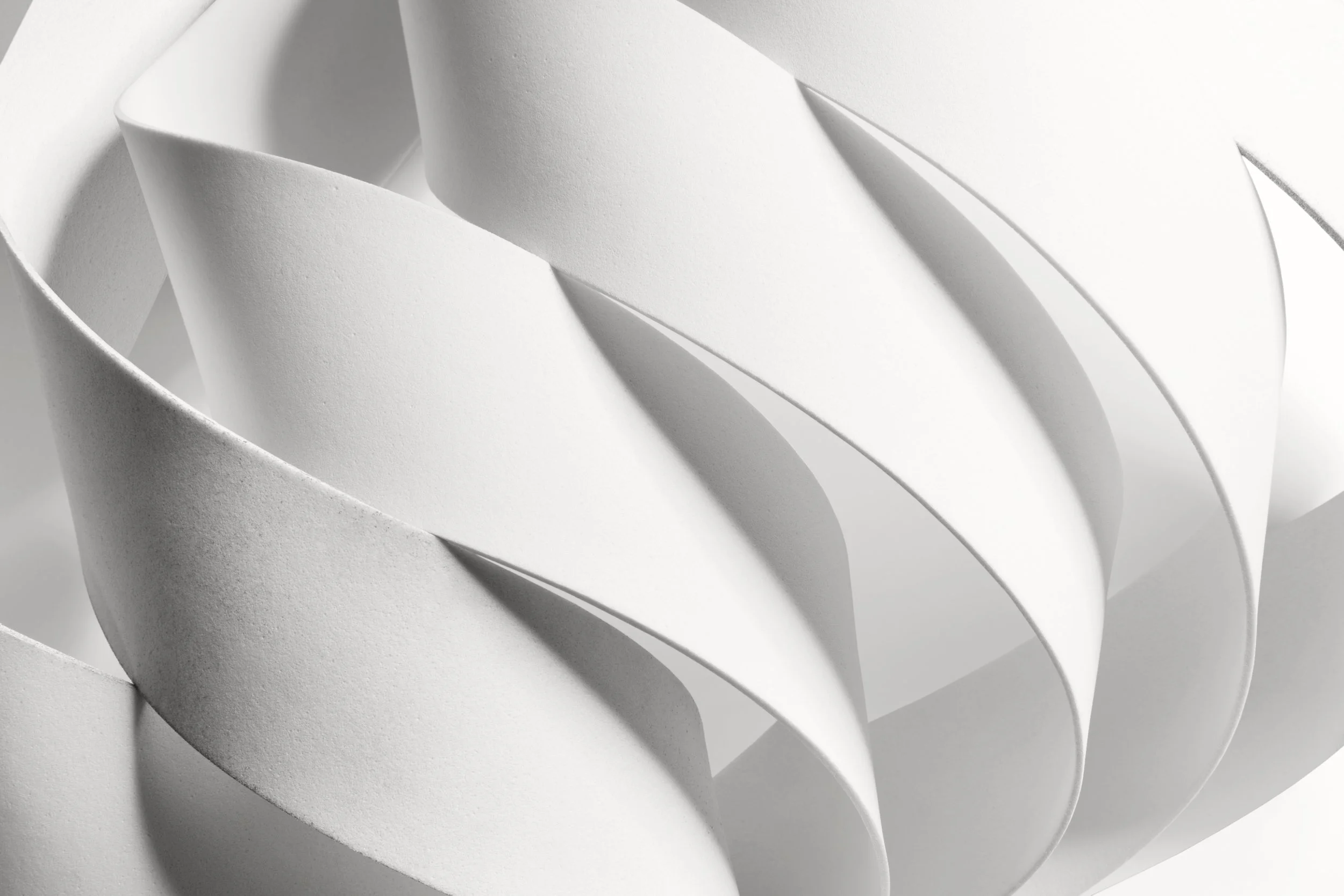 Close-up of layered, curved white strips with shadows symbolizing new ways of looking at how we build structure and a beautiful solution