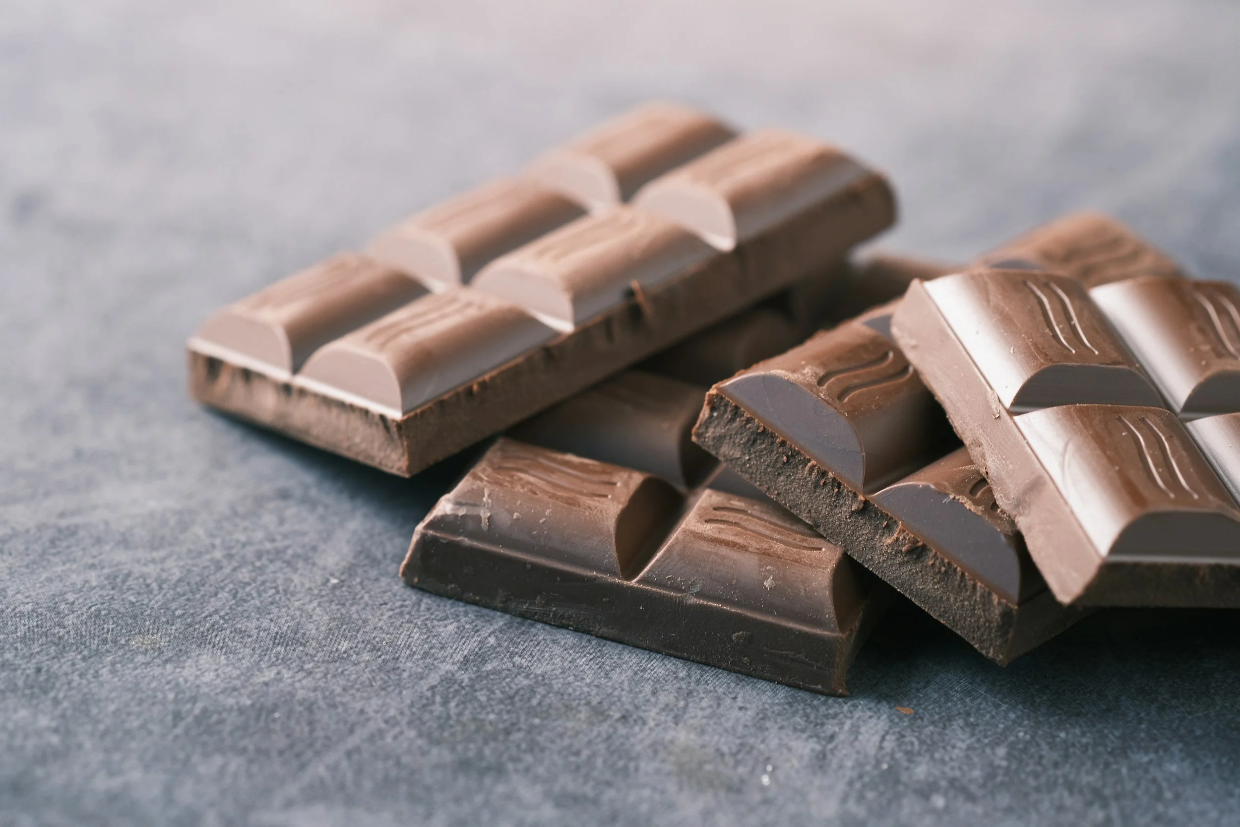 Close-up of assorted layered chocolate bars on a gray surface.