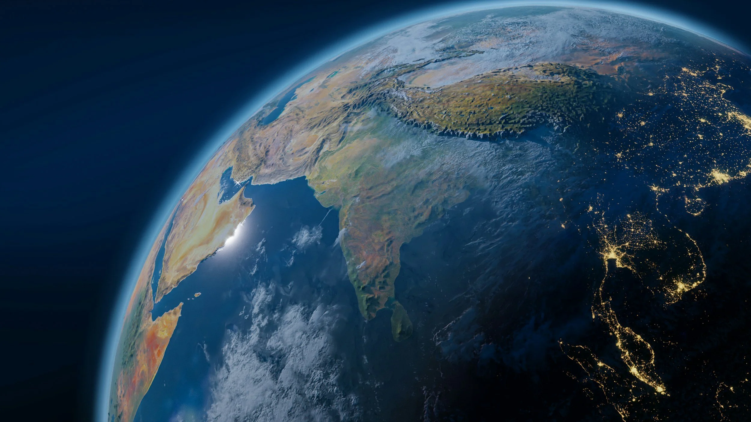 Satellite view of Earth showing continents, oceans, and city lights at night.