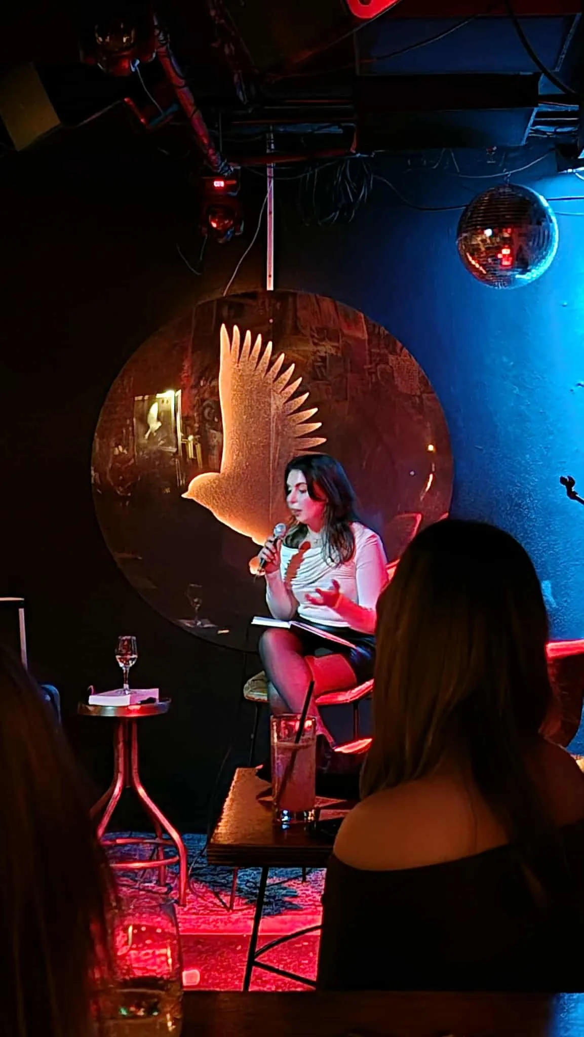 Eleni Gabrielides speaking on stage during a collaborative event, discussing sexual health, pleasure, and intimacy with an engaged audience.