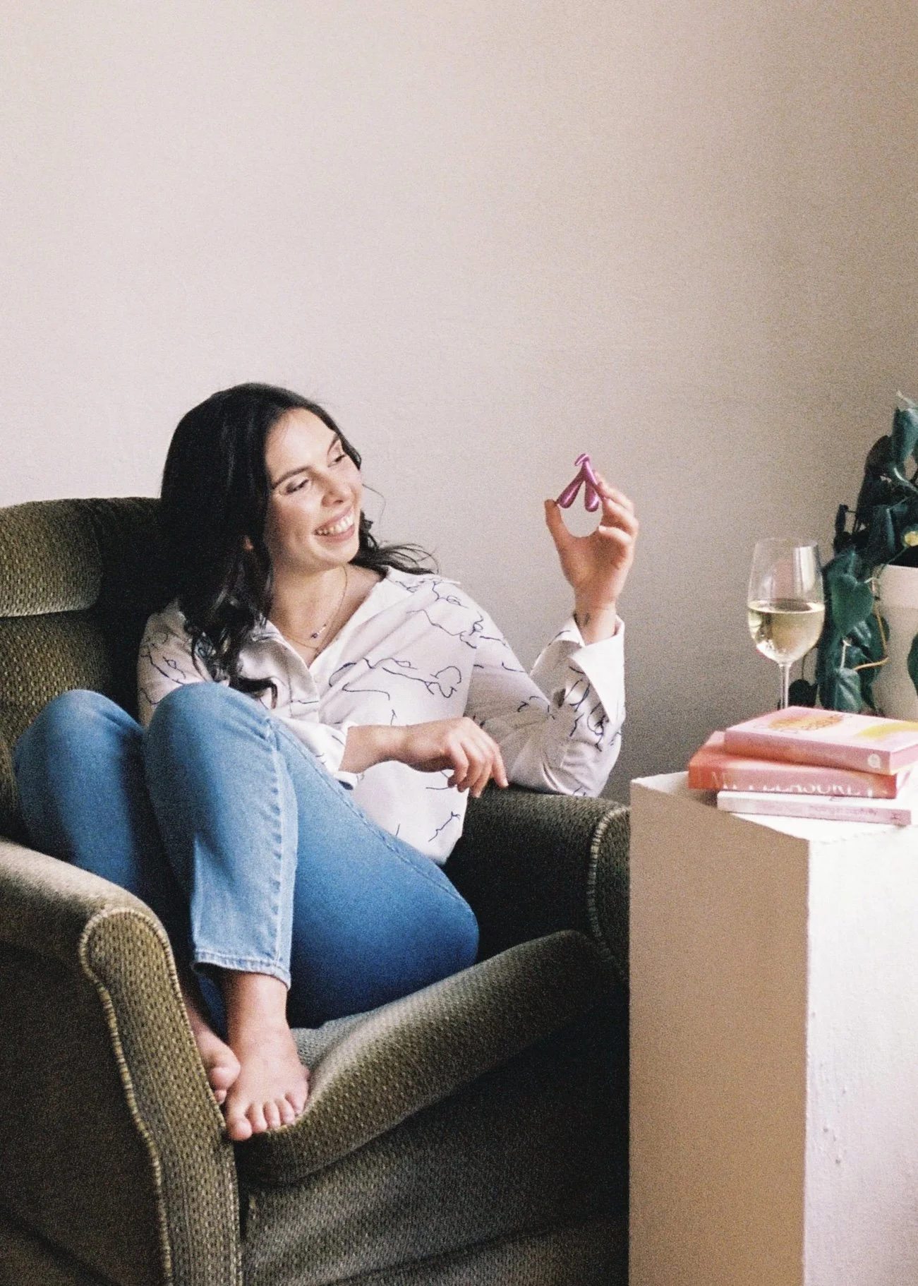 Eleni Gabrielides, Canberra-based sexologist, sitting in an armchair holding a clitoris model, preparing for an upcoming pleasure-centred talk or workshop.