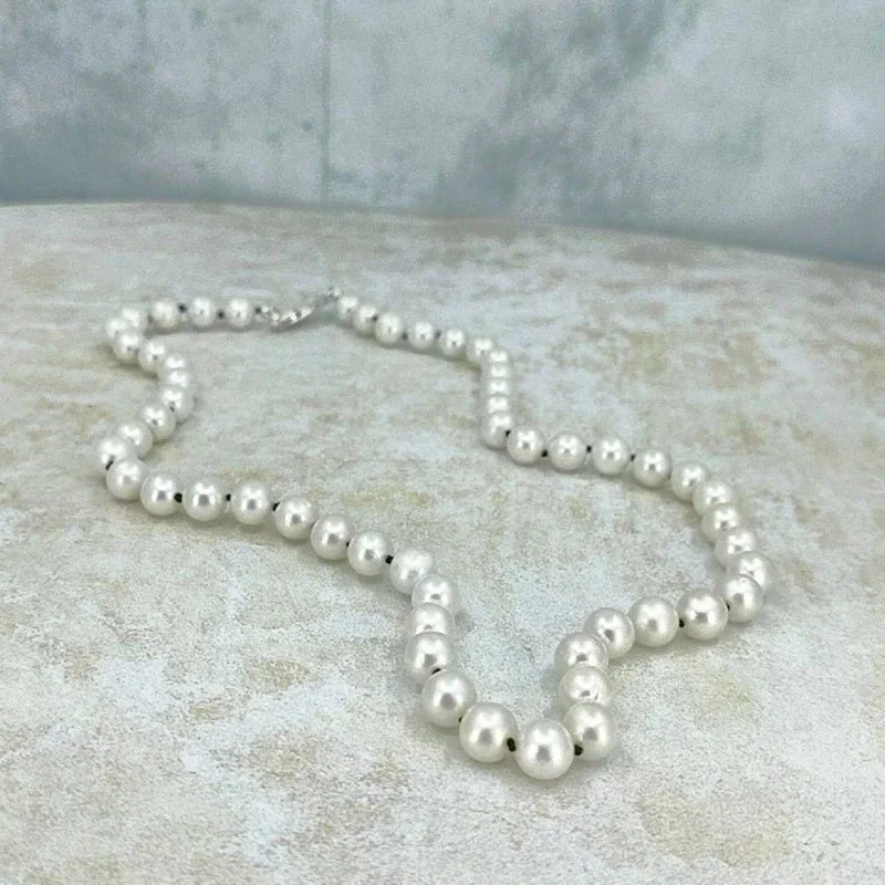 Strand of graduated pearls, from 5mm to 7mm on knotted silk with silver clasp.