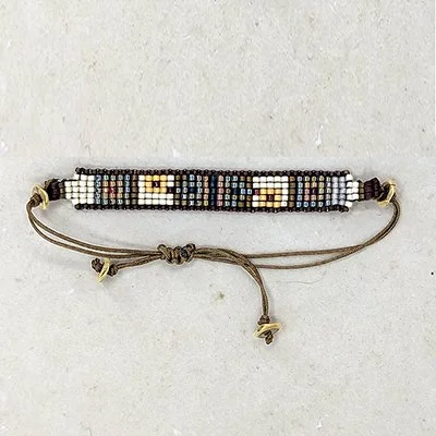 Beaded bracelet with adjustable cord and gold-tone end caps, featuring geometric bead patterns in neutral tones.