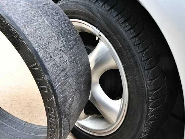 Close-up of Easydrift over a worn racing tire on the ground, showing the difference in tread wear.