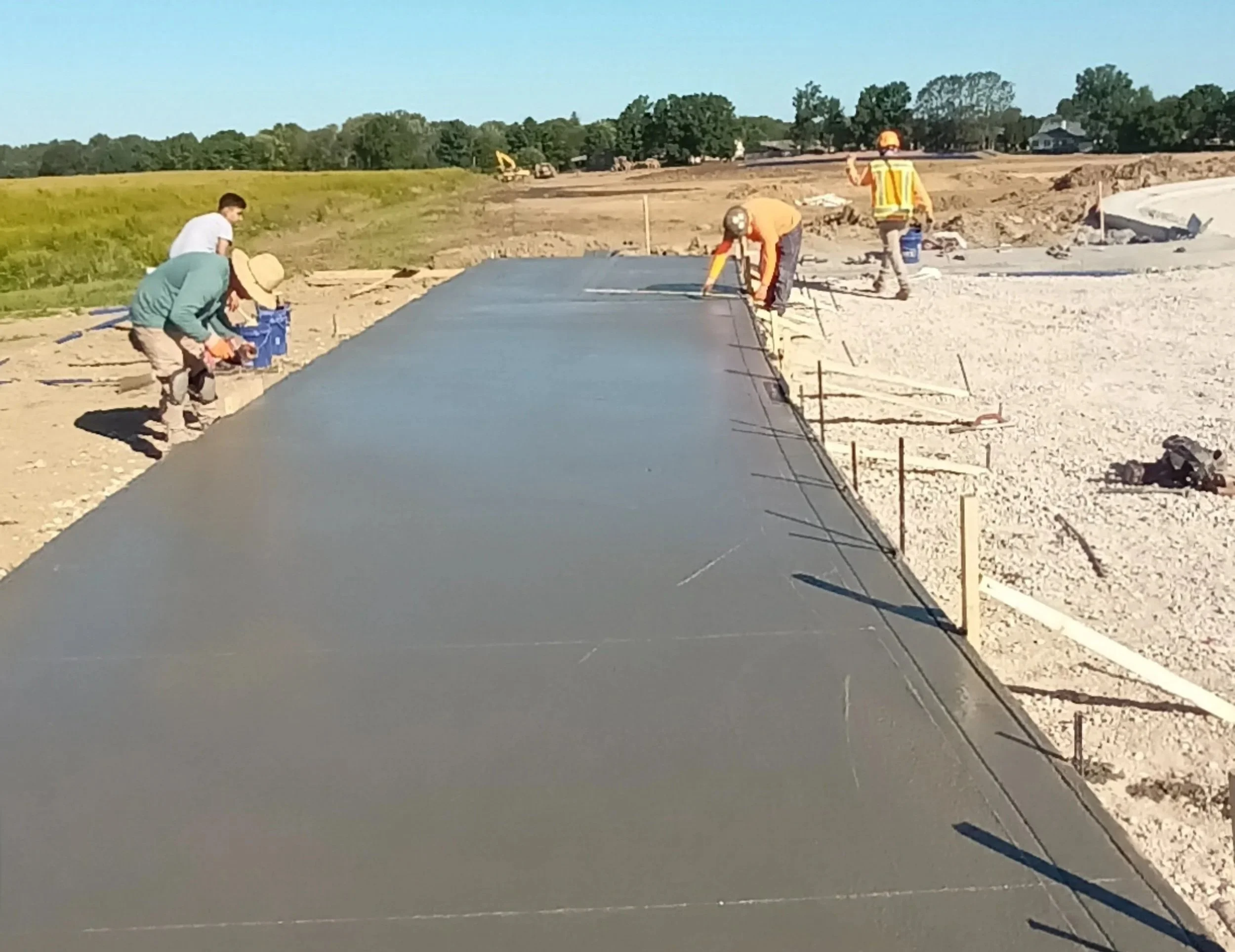 Construction workers laying a concrete slab on a construction site.