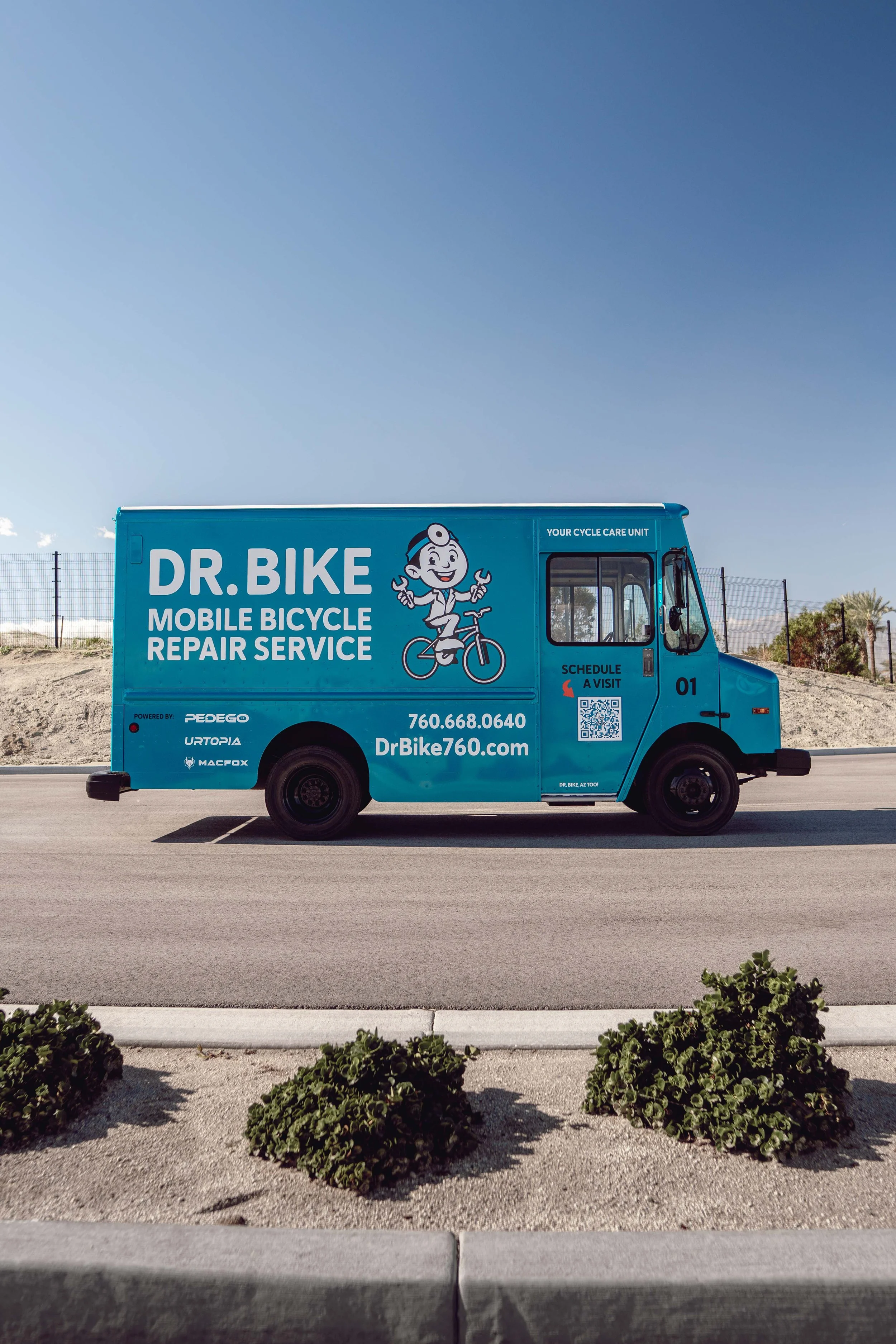 Blue mobile bicycle repair service truck labeled 'Dr. Bike' parked on the street.