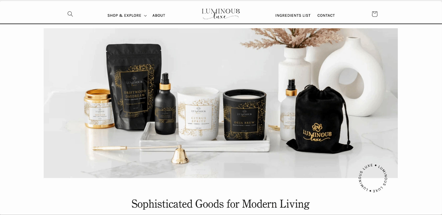 A flat lay of luxury home fragrance products, including candles, sprays, and packaging, on a tray with decorative vases in the background.