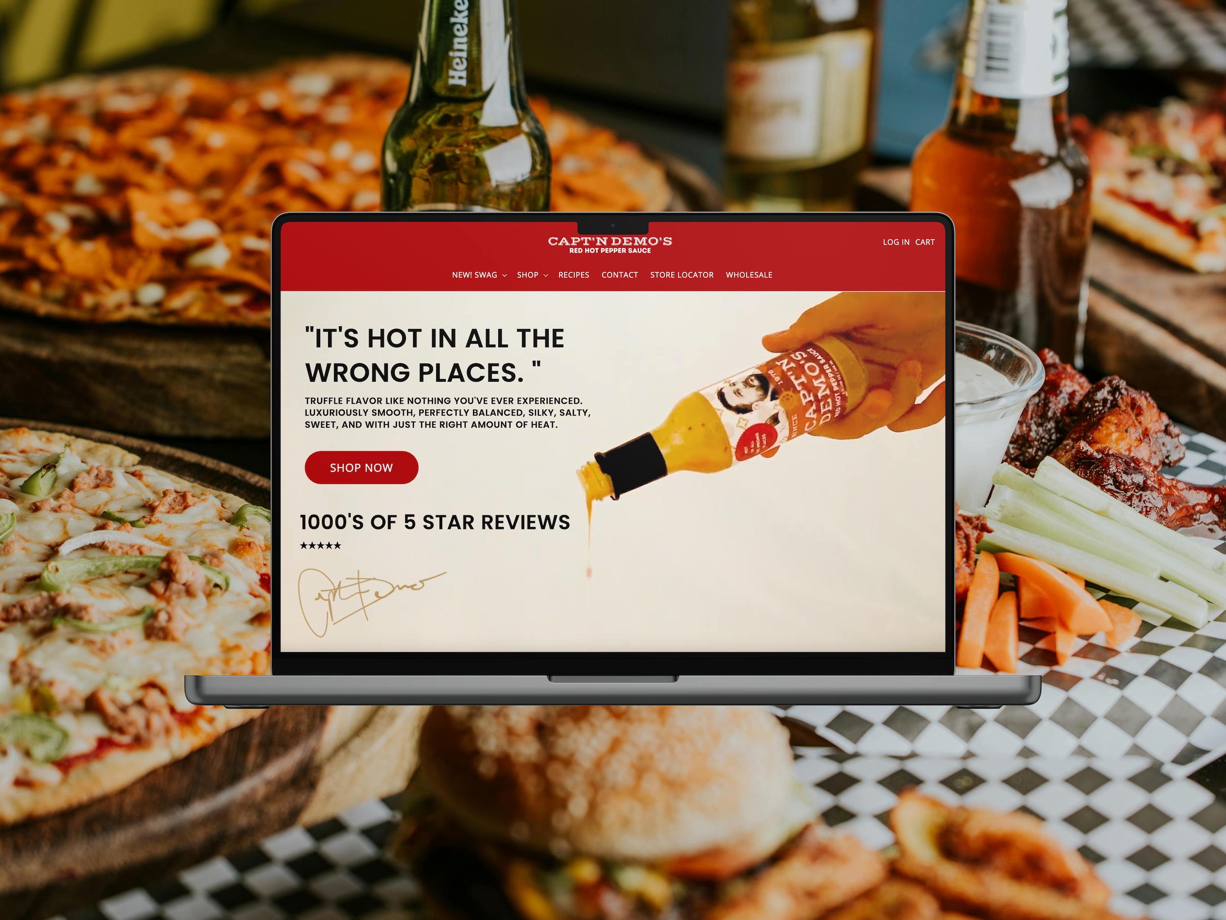 Laptop displaying a website for Captain Demo's hot sauce, with pizza in the background.