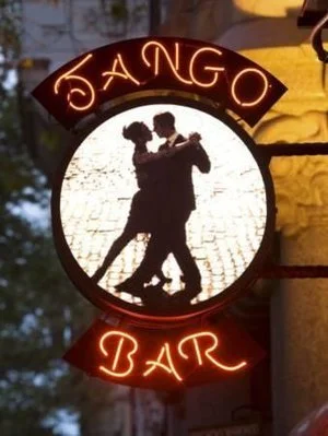 Circular sign for "Tango Bar" with silhouette of a dancing couple.