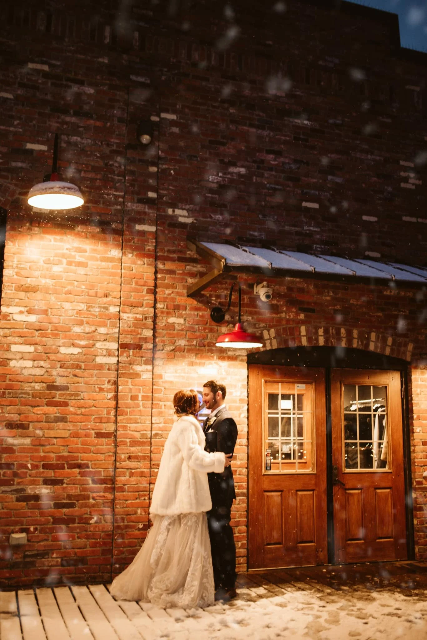 Newlywed couple kissing at the entrance of Twenty Seven Event Venue in downtown Little Rock