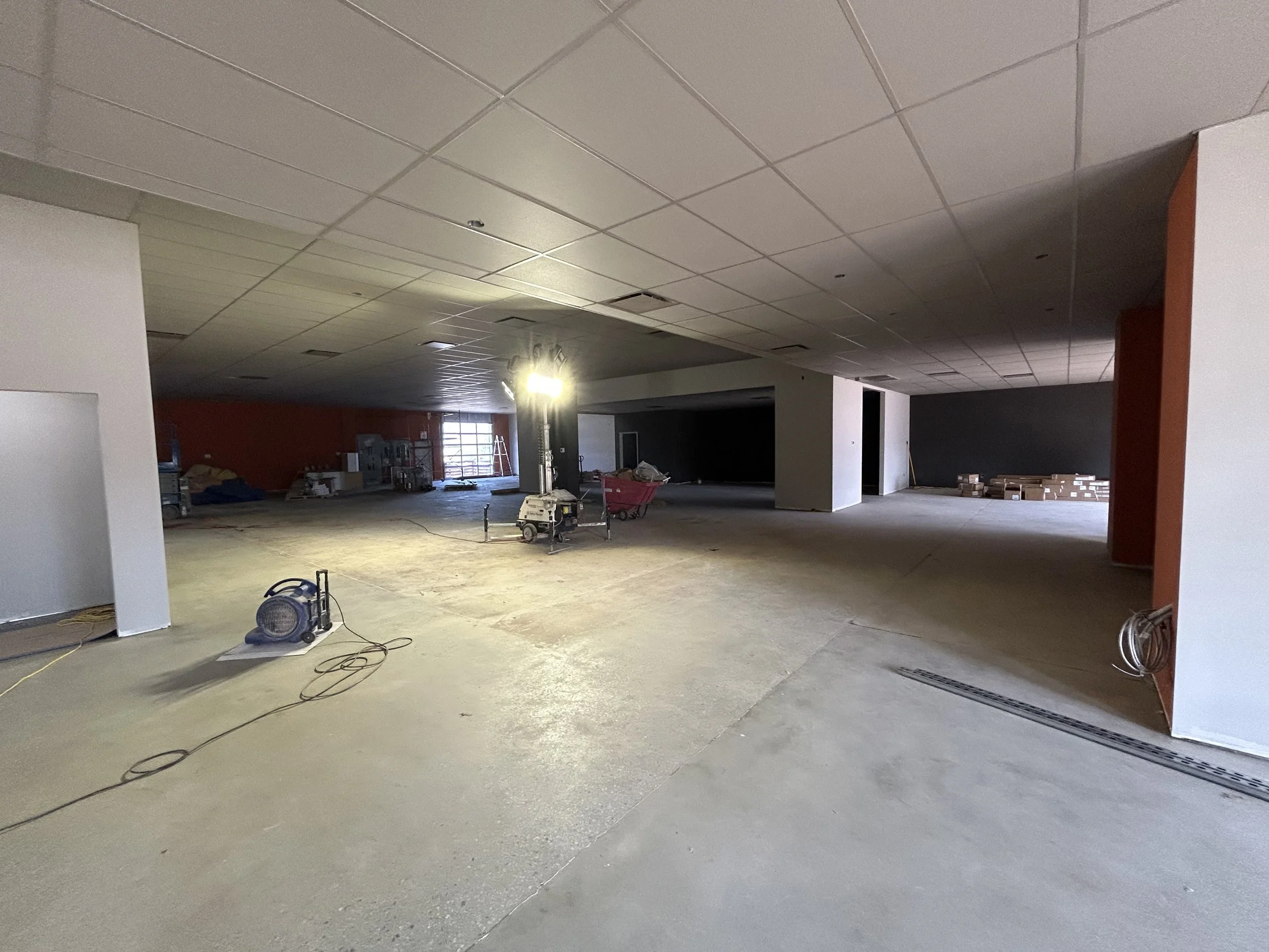 Crucible Fit gym interior during construction, showing open floor space and unfinished flooring.