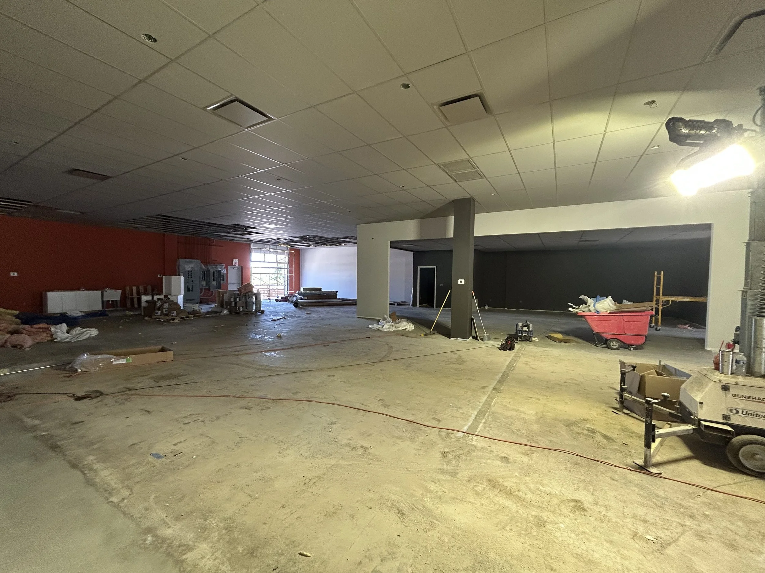 Crucible Fit gym construction progress with installed ceiling lights and unfinished flooring.