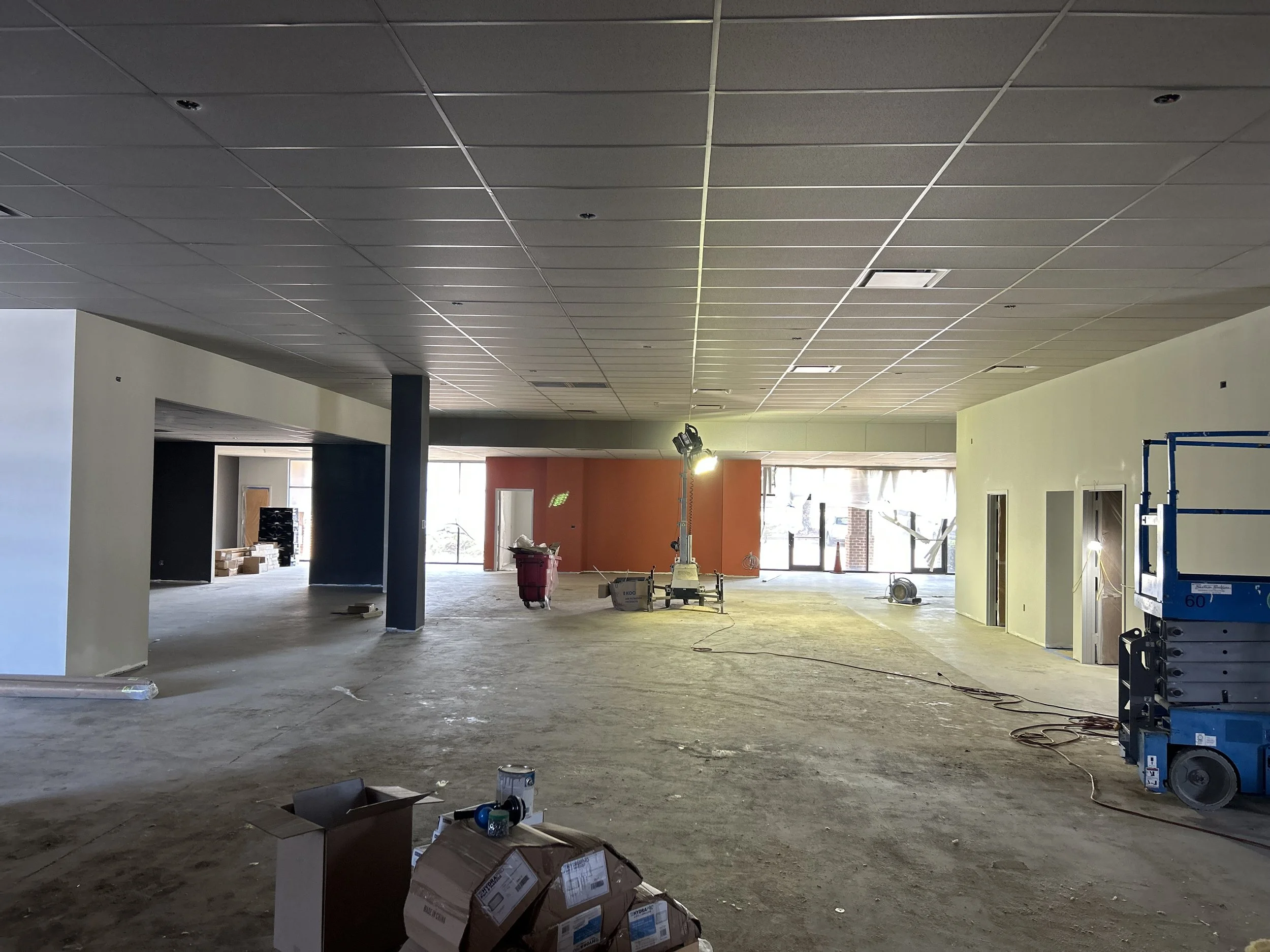 Crucible Fit interior buildout with partially finished ceilings, unfinished floors, and equipment awaiting installation.
