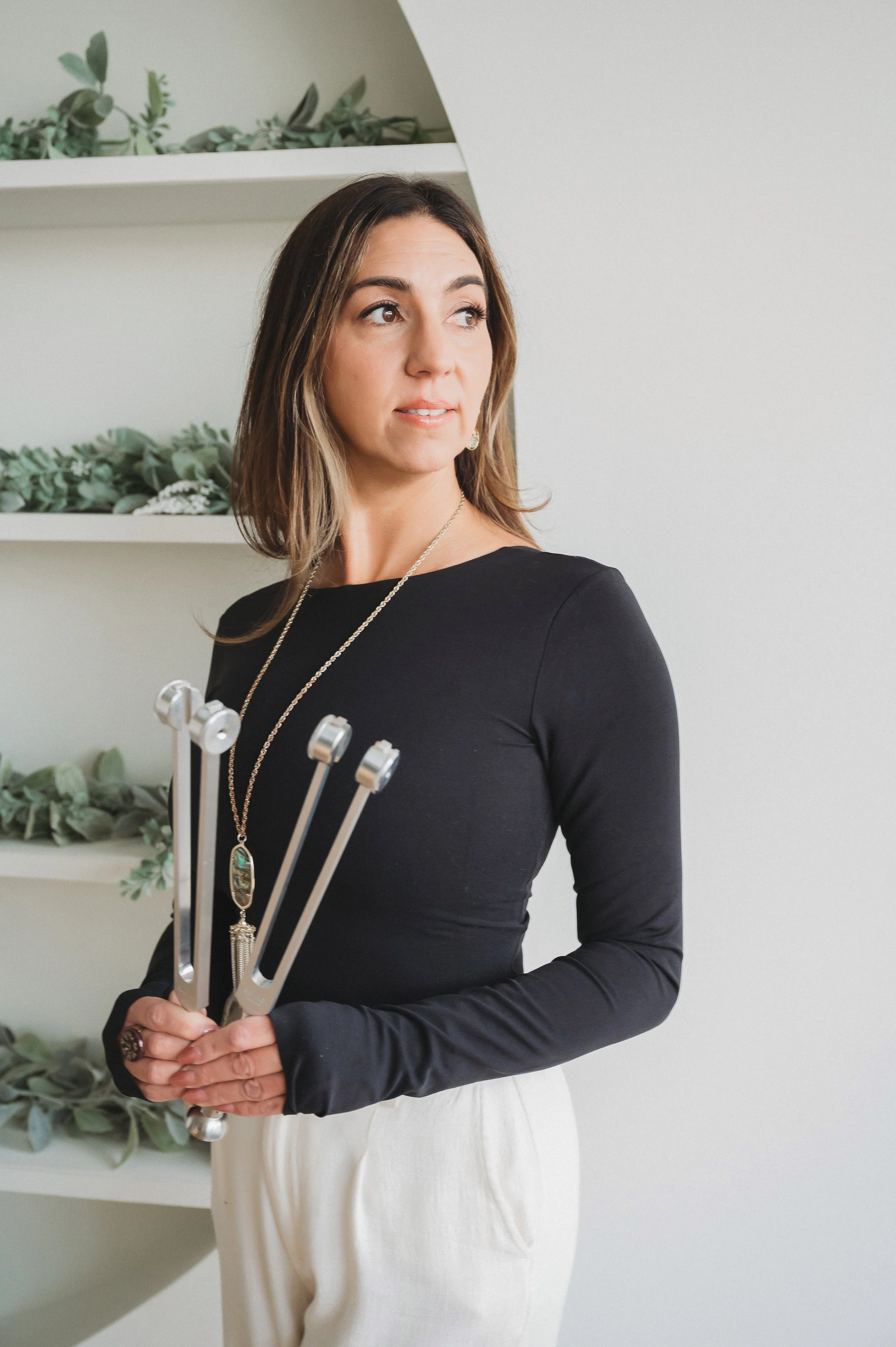 Amanda Gandolfo holding tuning forks for sound and nervous system wellness practices.