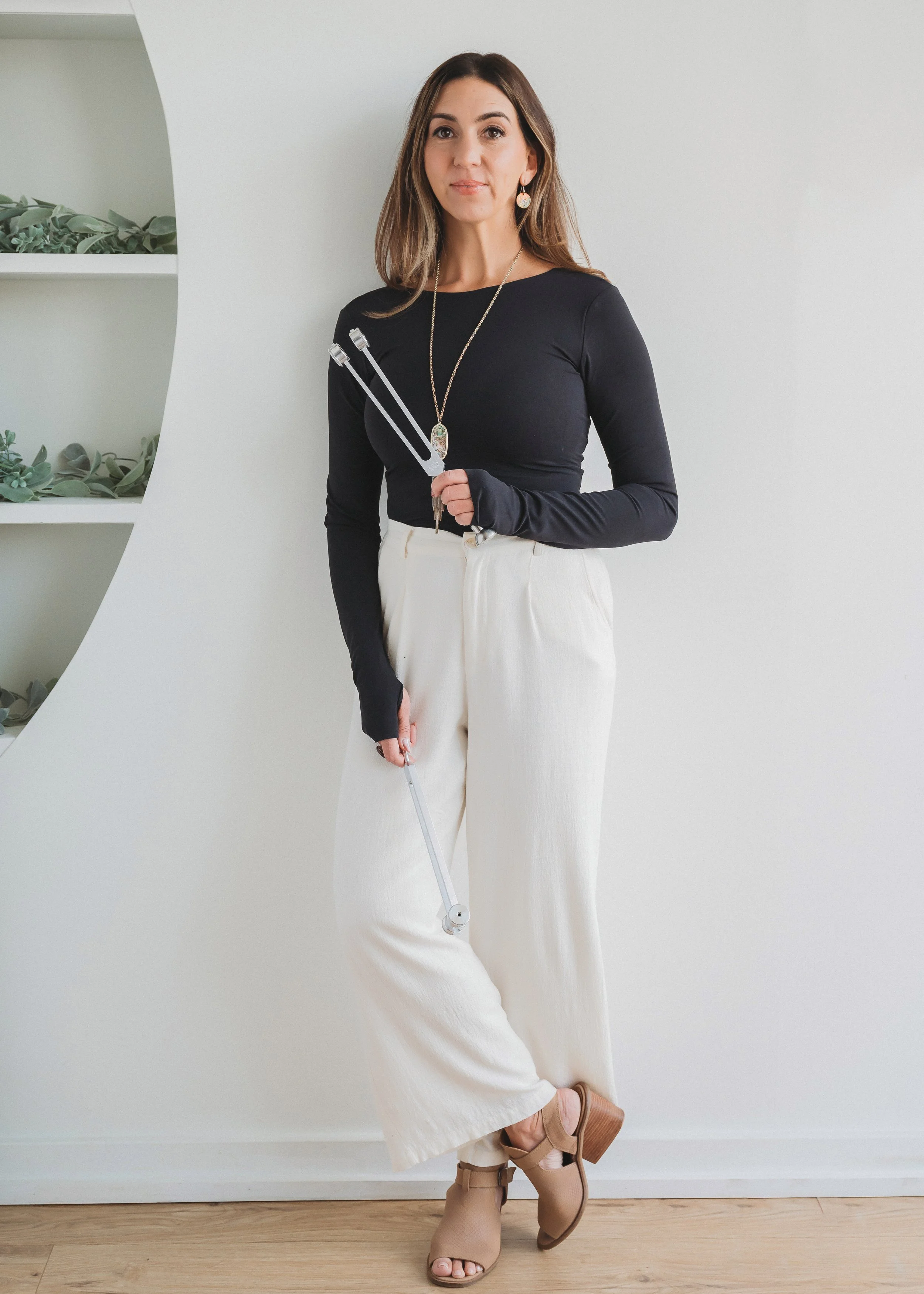 Amanda Gandolfo, Biofield Tuning practitioner, holding tuning forks in her Long Island sound wellness practice.