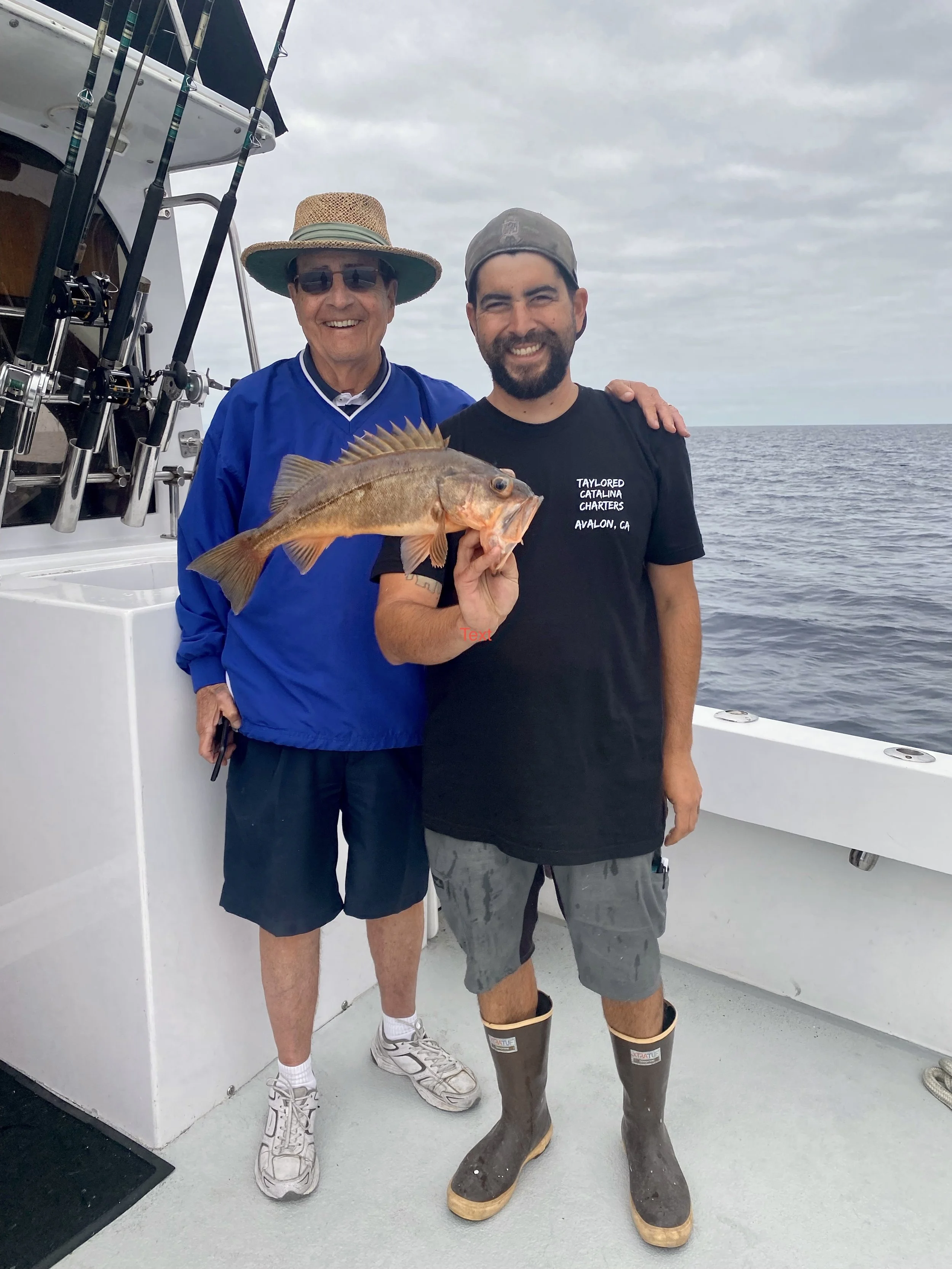 Captain and grandfather holding a fish aboard Taylored Catalina Charters fishing charter yacht Breann's Revenge on Catalina Island