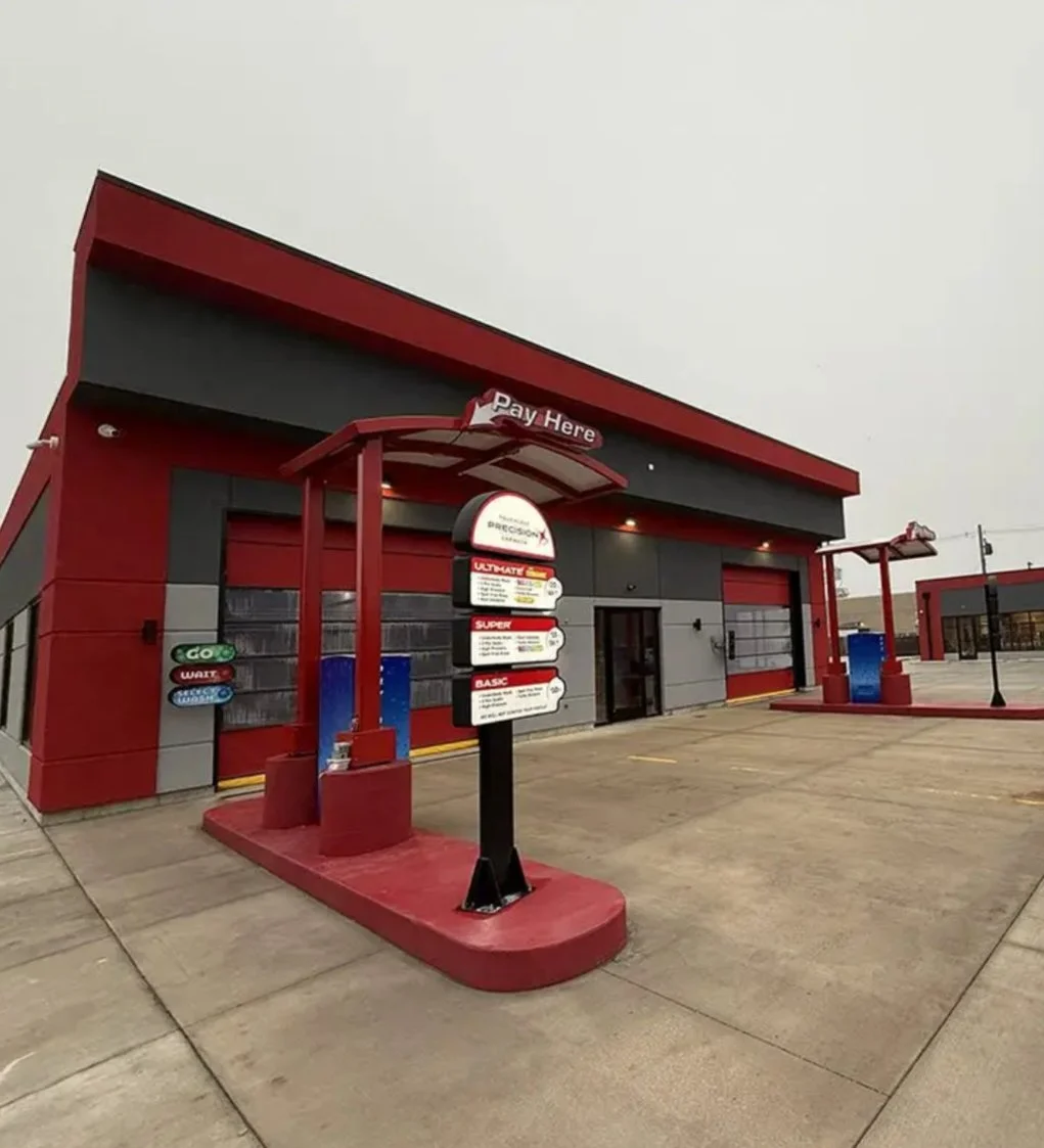 Fast food drive-thru restaurant with a payment menu board, red and gray exterior, and no cars in the parking lot.