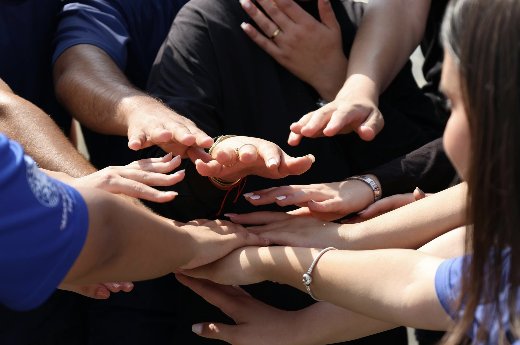 Teammates extend their open hands in a show of solidarity